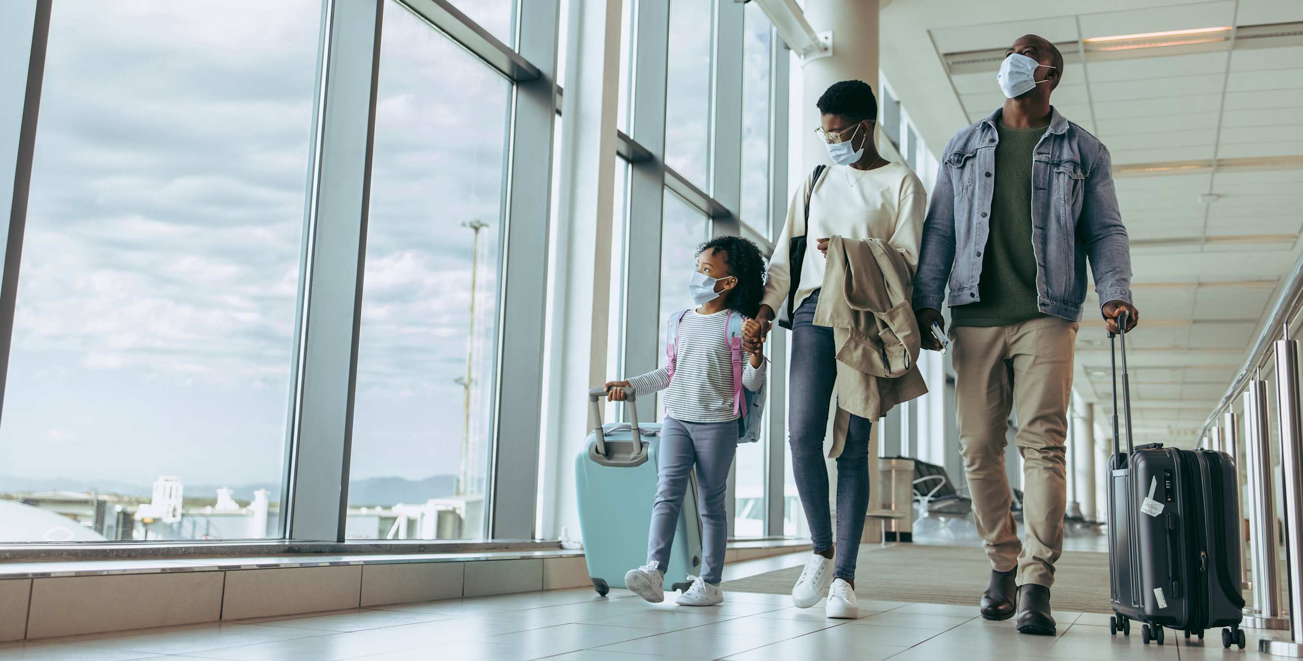 A family walks down the hallway on the airport.
