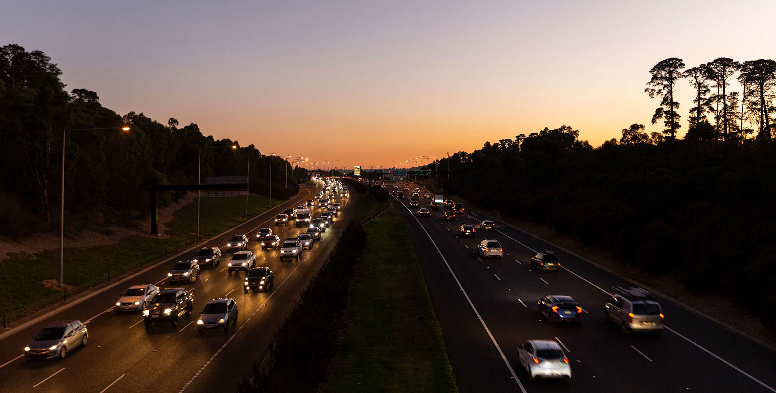 Cars drive on a California highway at dusk.