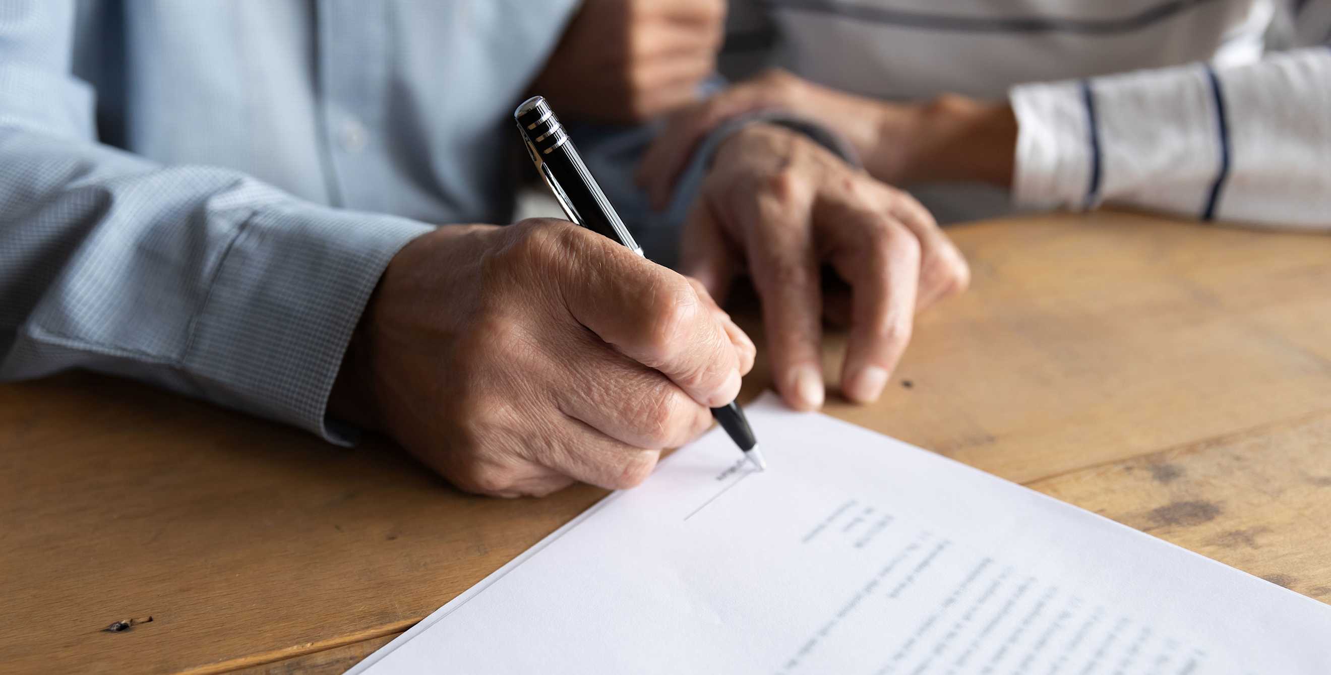 A couple signs a legal document with a notary.