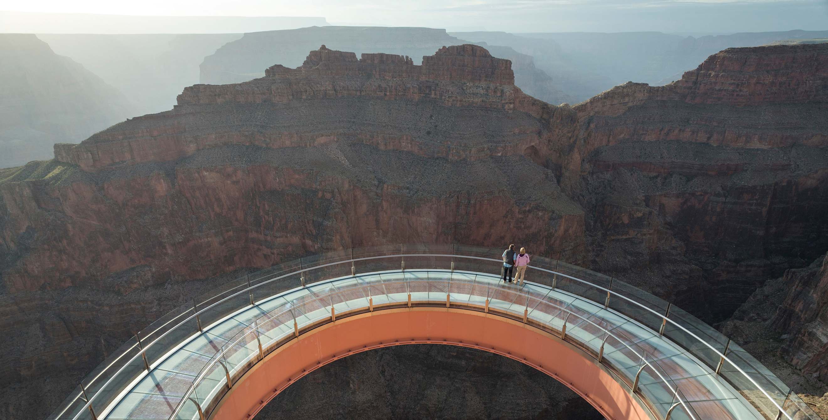 A couple stand at the center of the Grand Canyon Skywalk in Grand Canyon National Park.