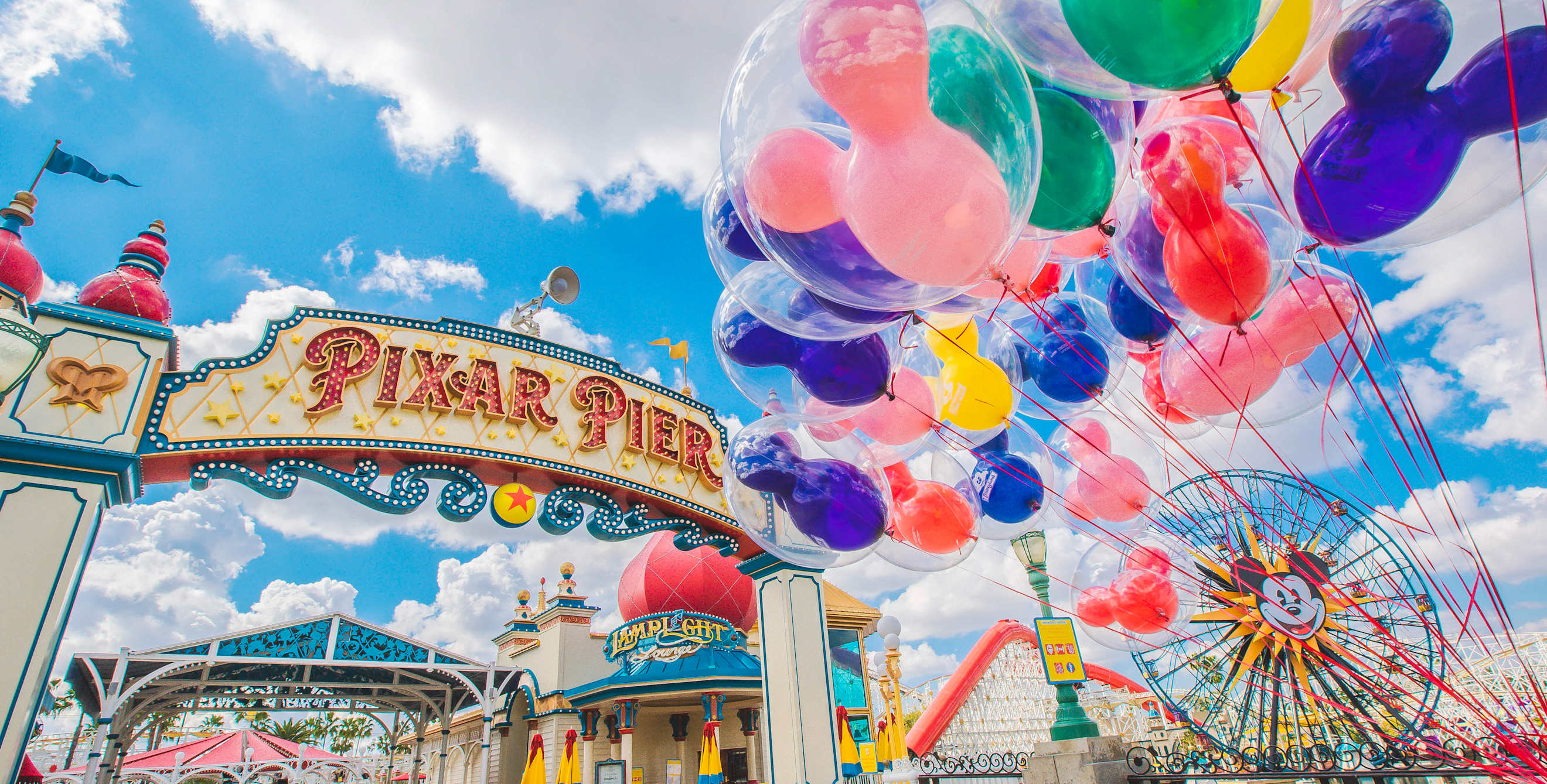 mickey mouse balloons float at the entrance to pixar pier at california adventure