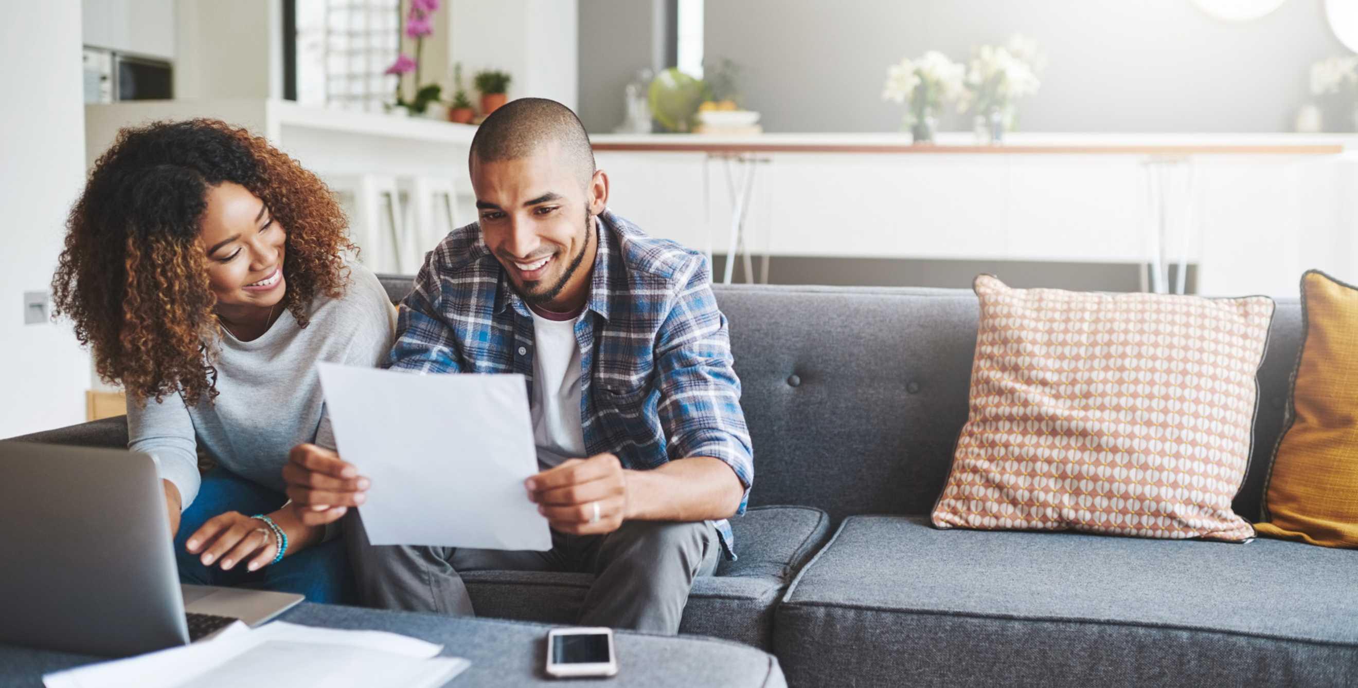 Couple sitting on the couch reading a paper