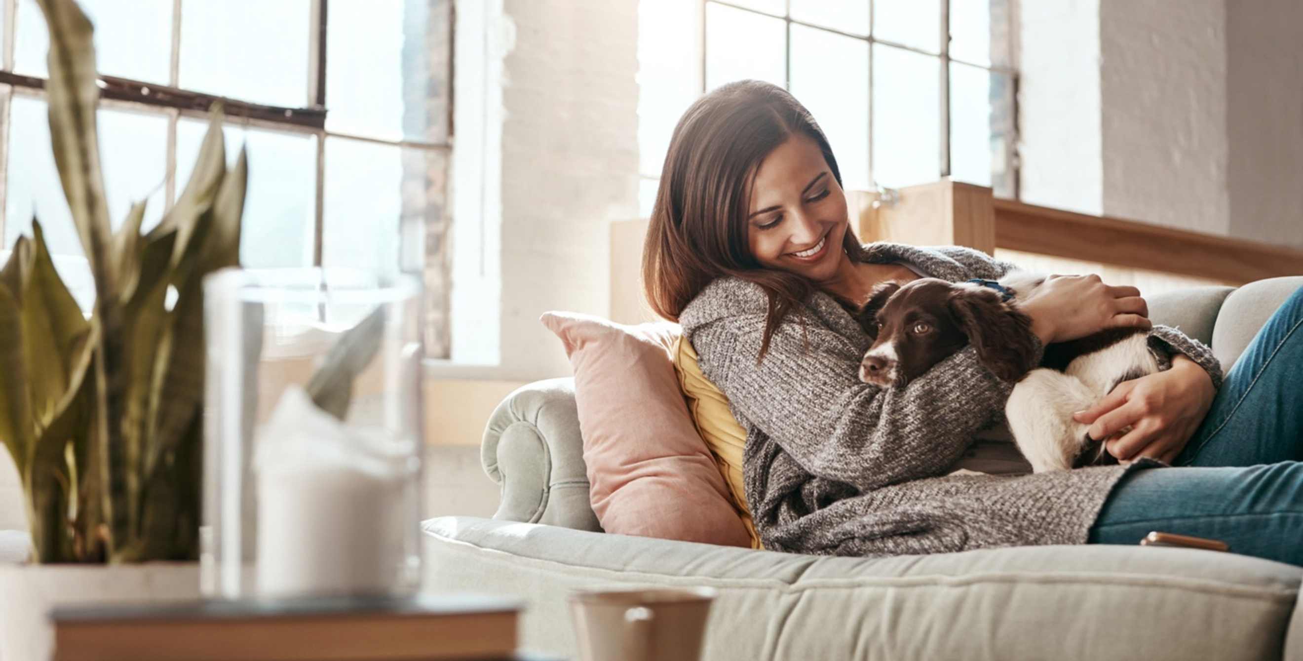 Woman lying on the couch with a dog