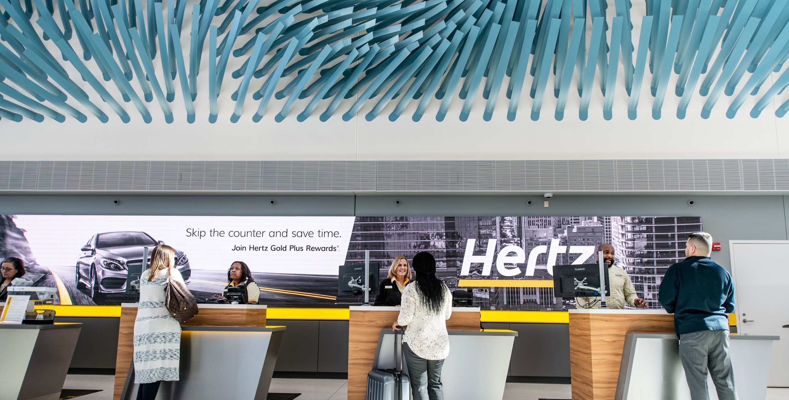 Customers pick up their rental cars at the Hertz service counter.