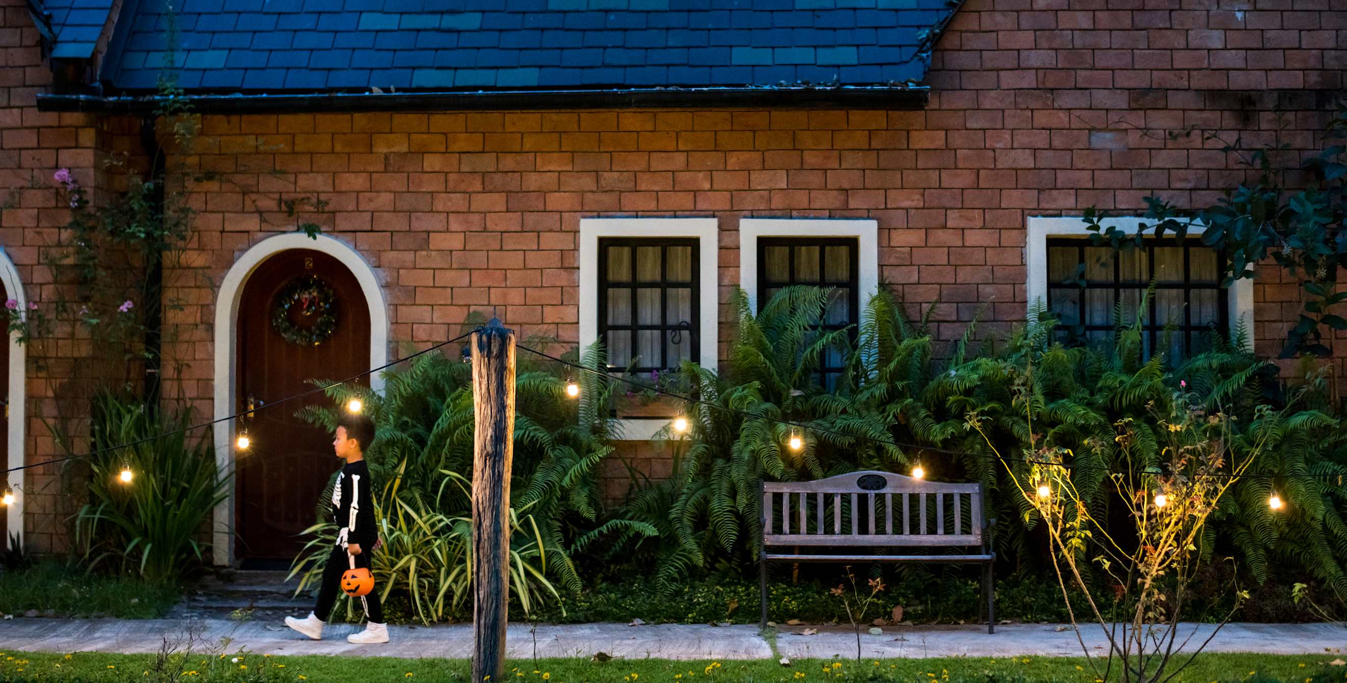 A child walks by string lights on Halloween.