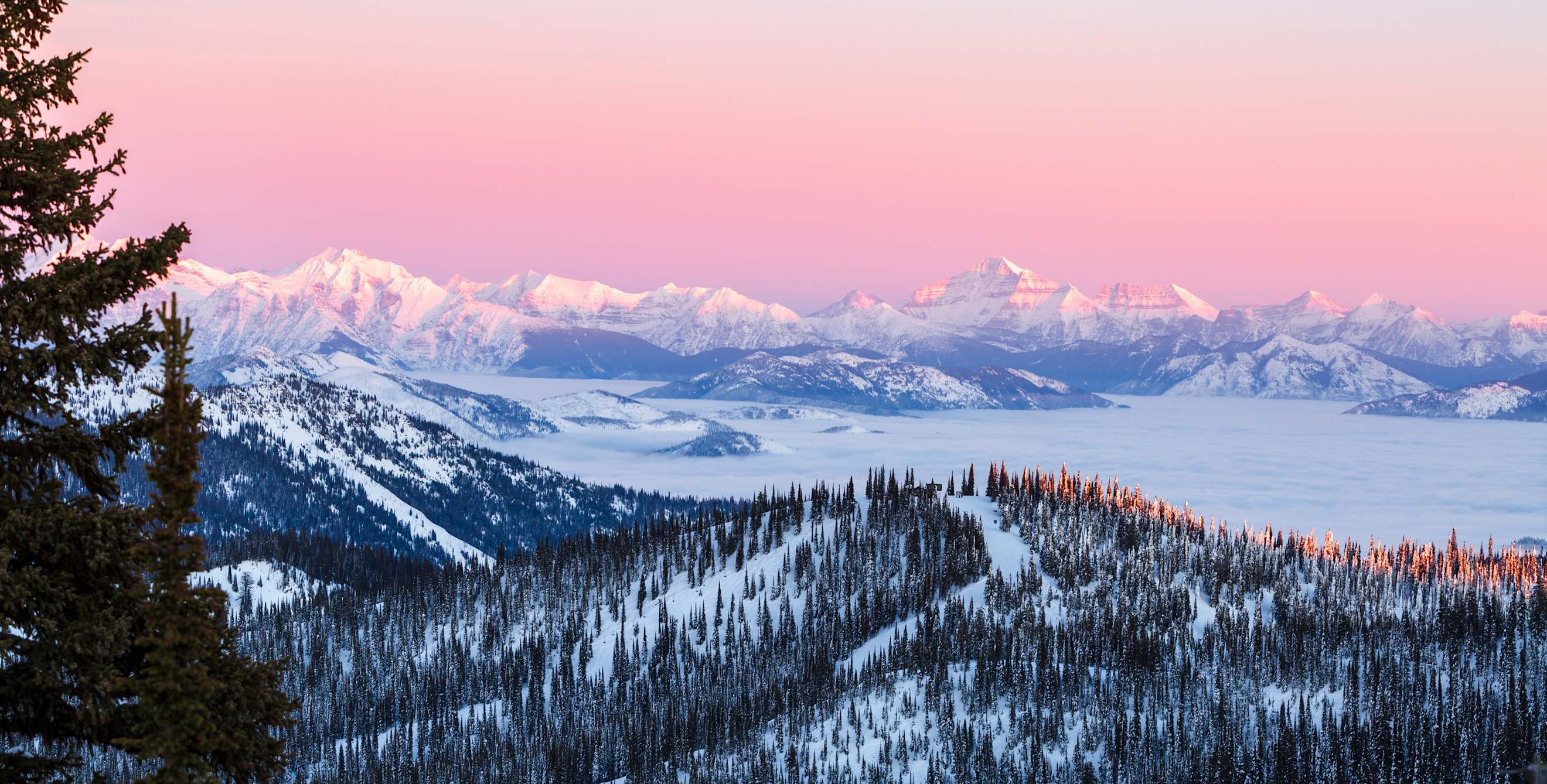 Sunset reflects across the snow in Glacier National Park.