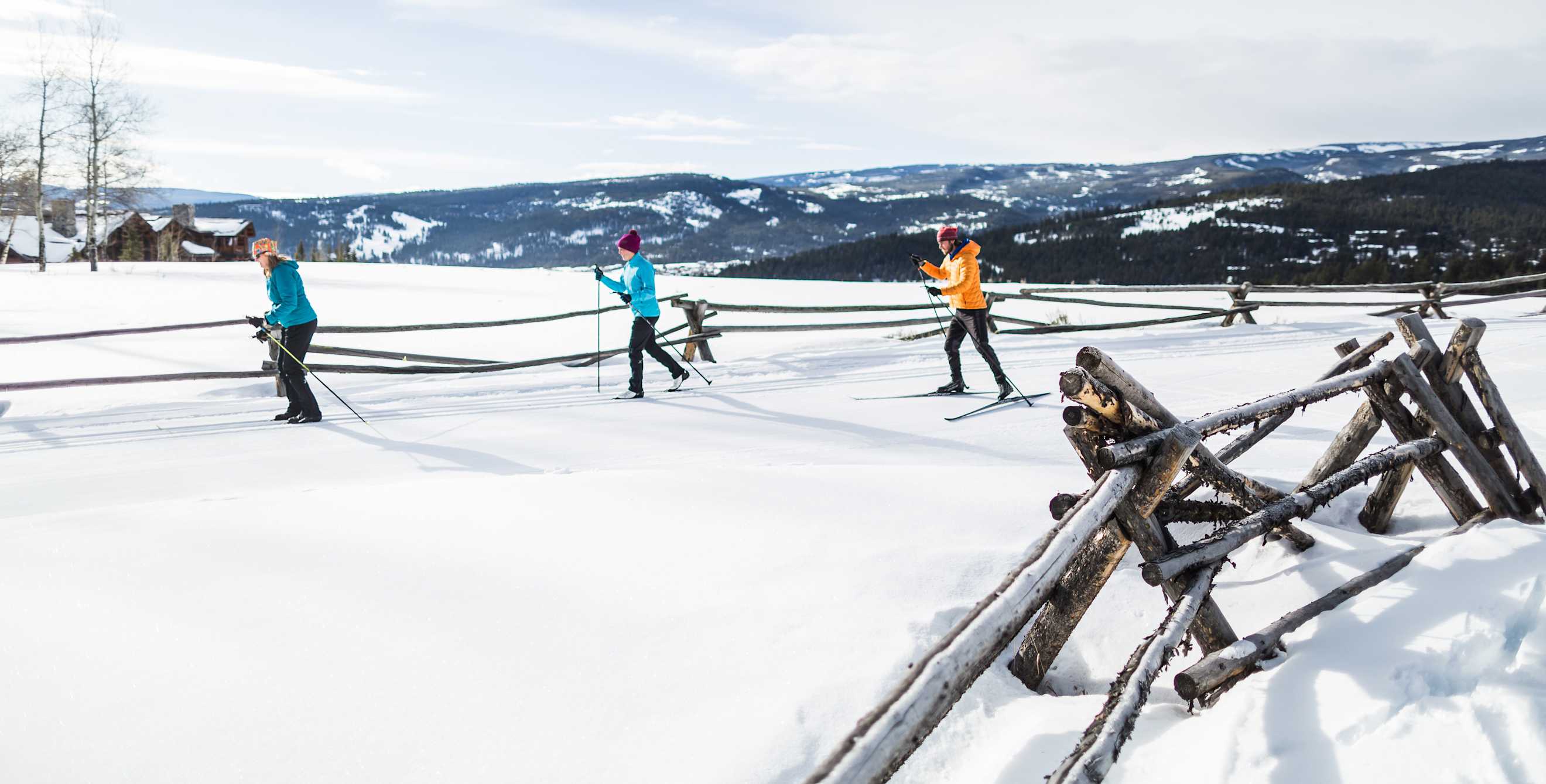 Three cross-country skiers on a trail at Lone Mountain Ranch in Big Sky Montana.