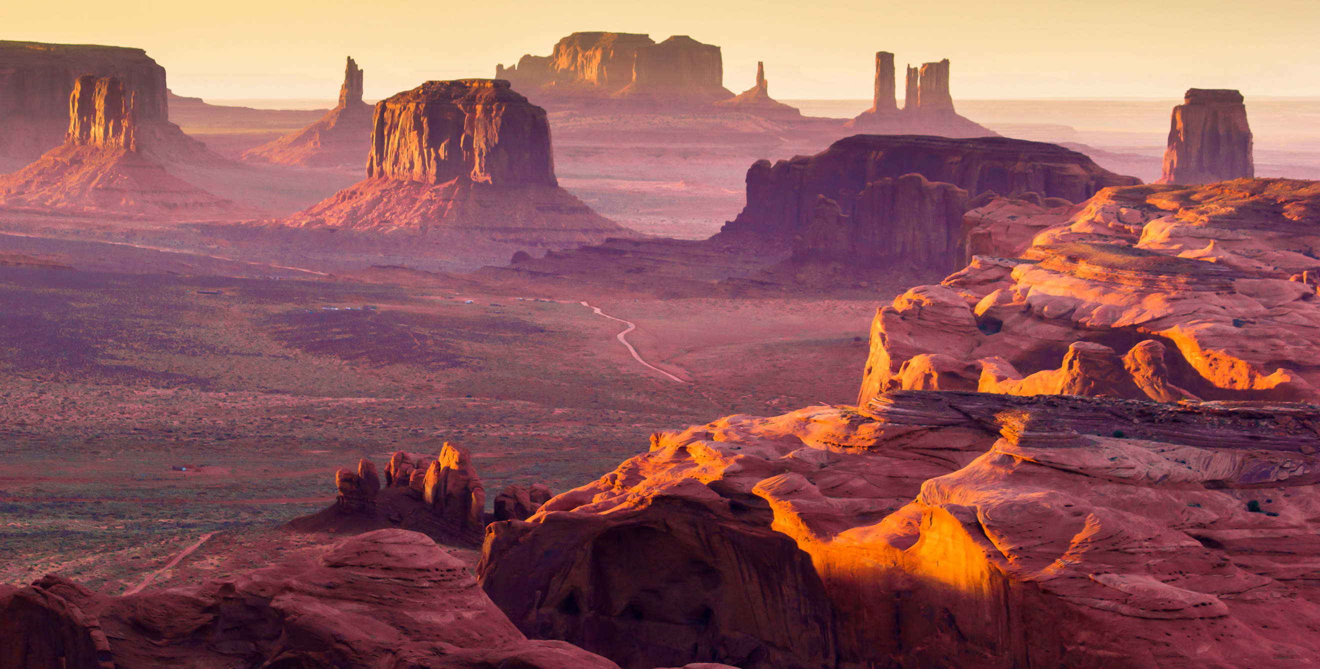 A dirt road winds through Monument Valley Navajo Tribal Park in Arizona.