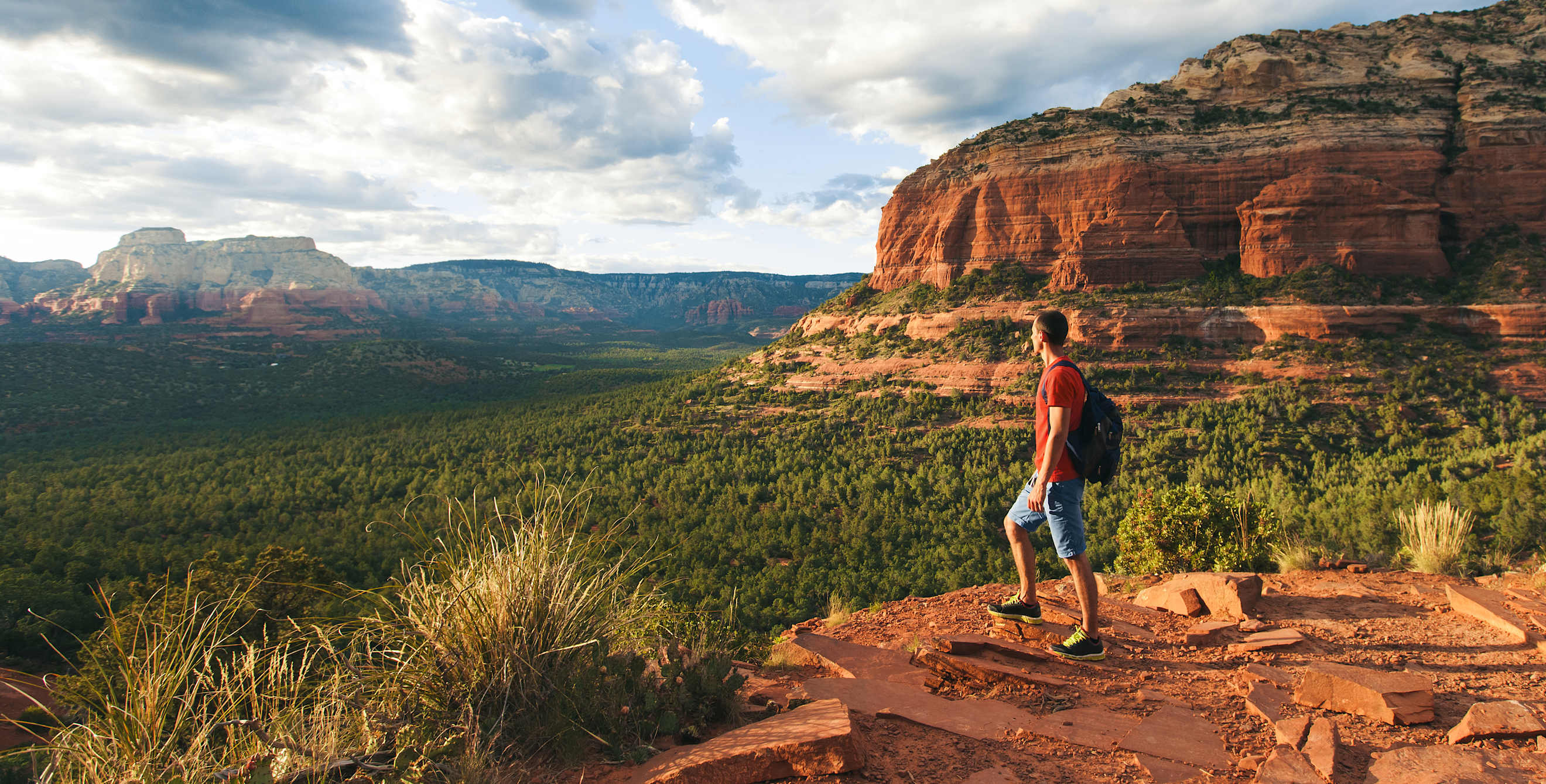 A hiker stands at an overlook in Sedona, Arizona.