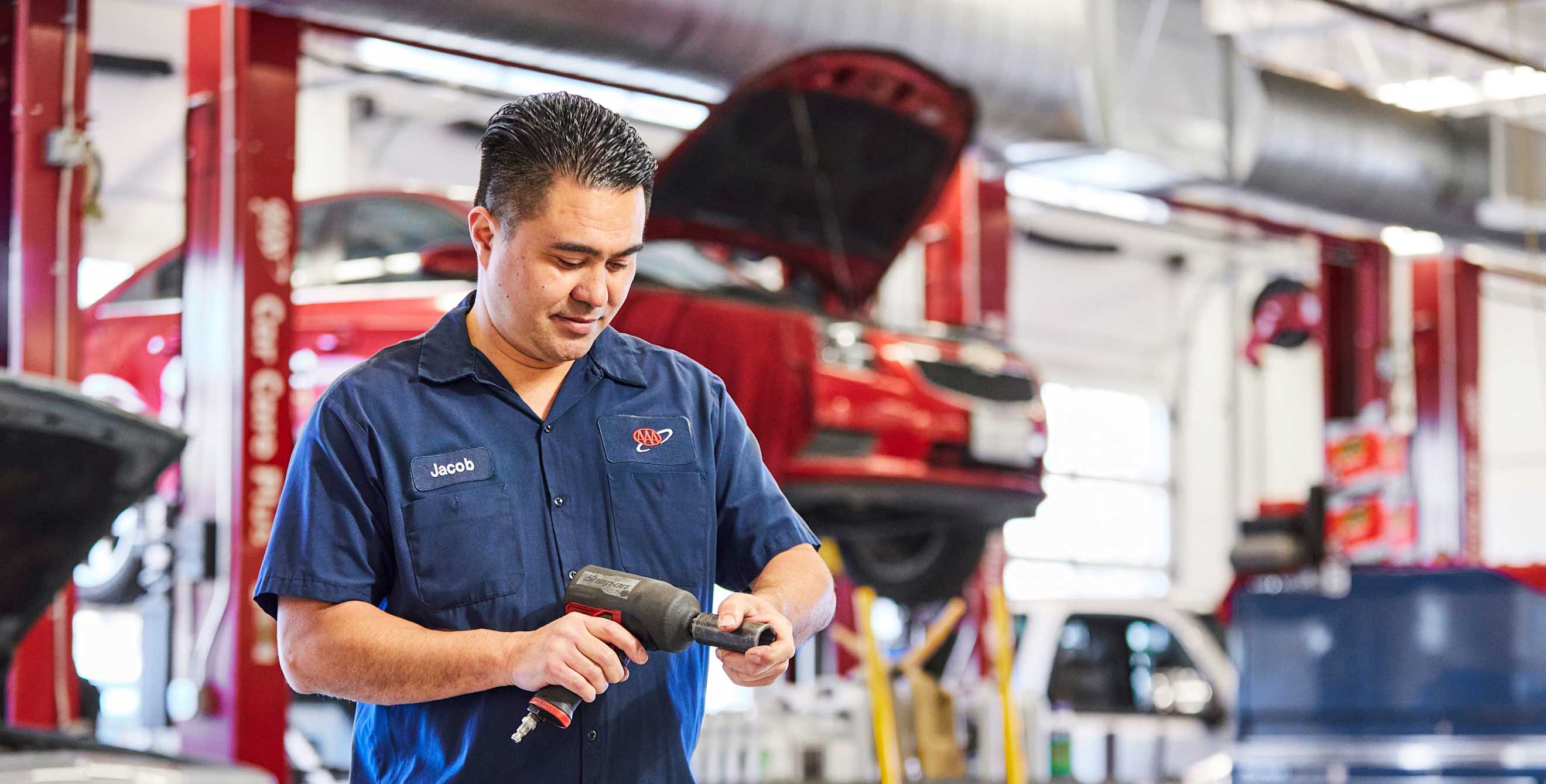 A mechanic prepares a tool in a AAA repair shop