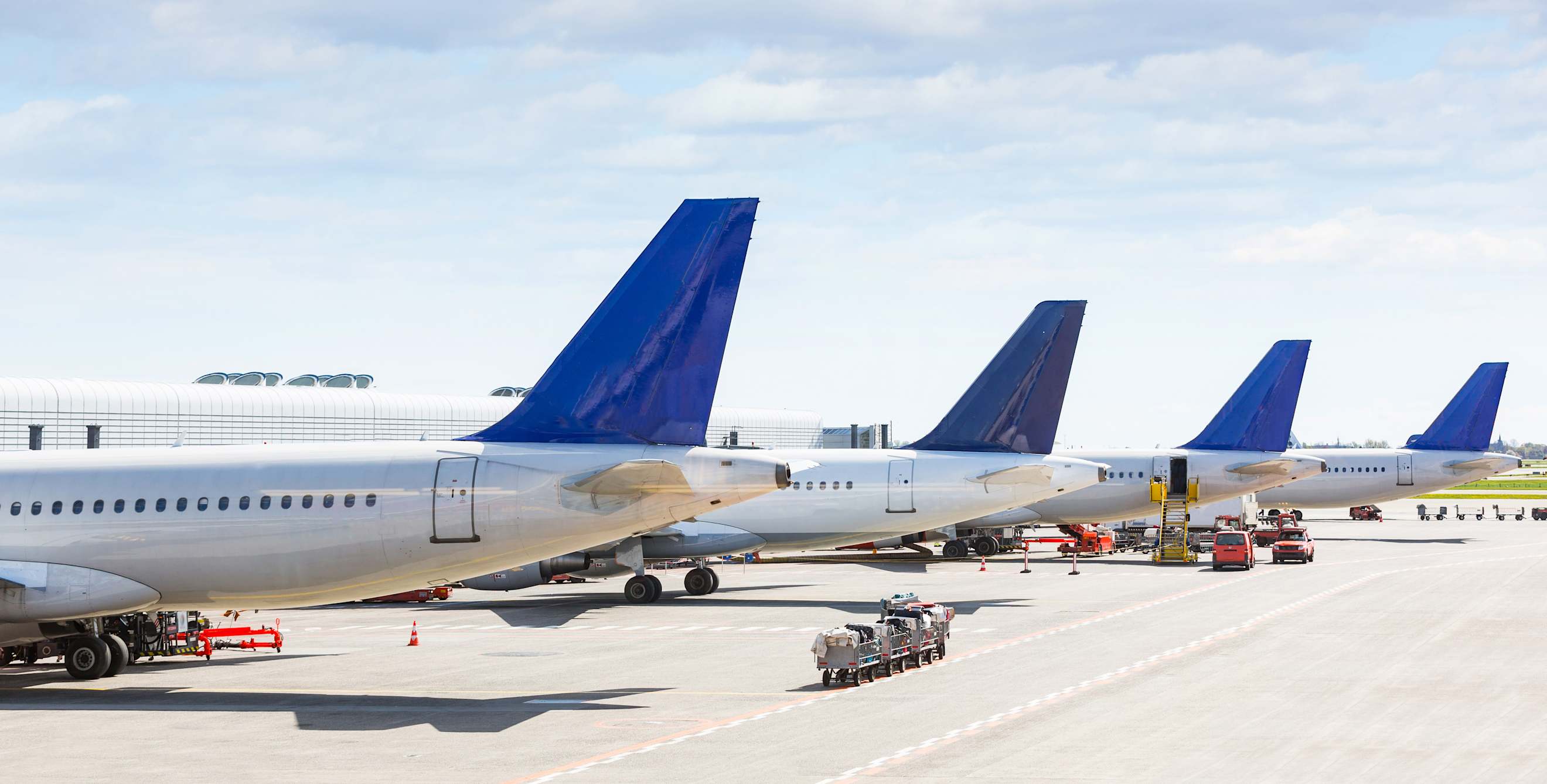 Planes lined up at the gates outside of an airport terminal.