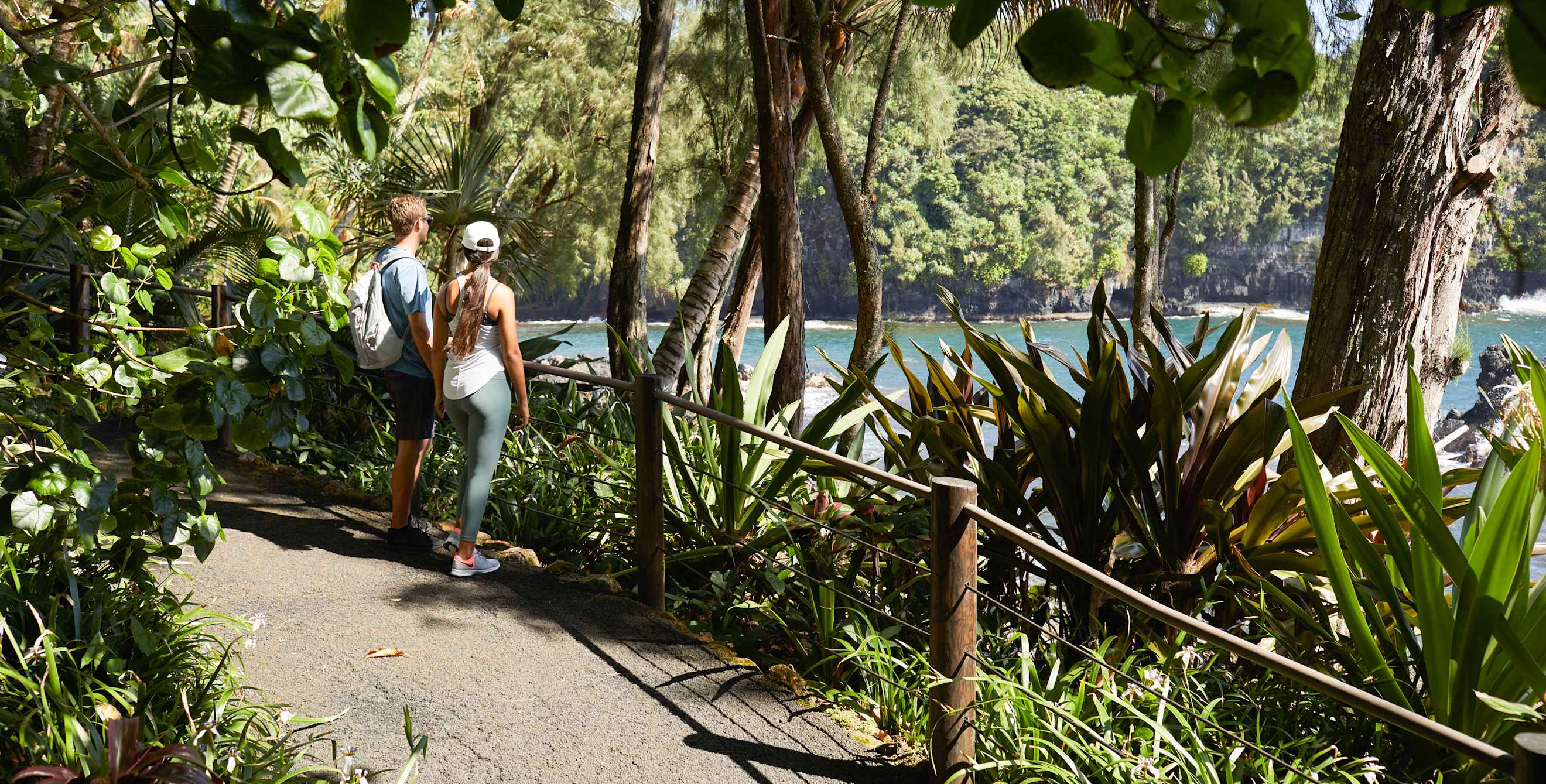 A couple walk through the Hawai‘i Tropical Botanical Garden.