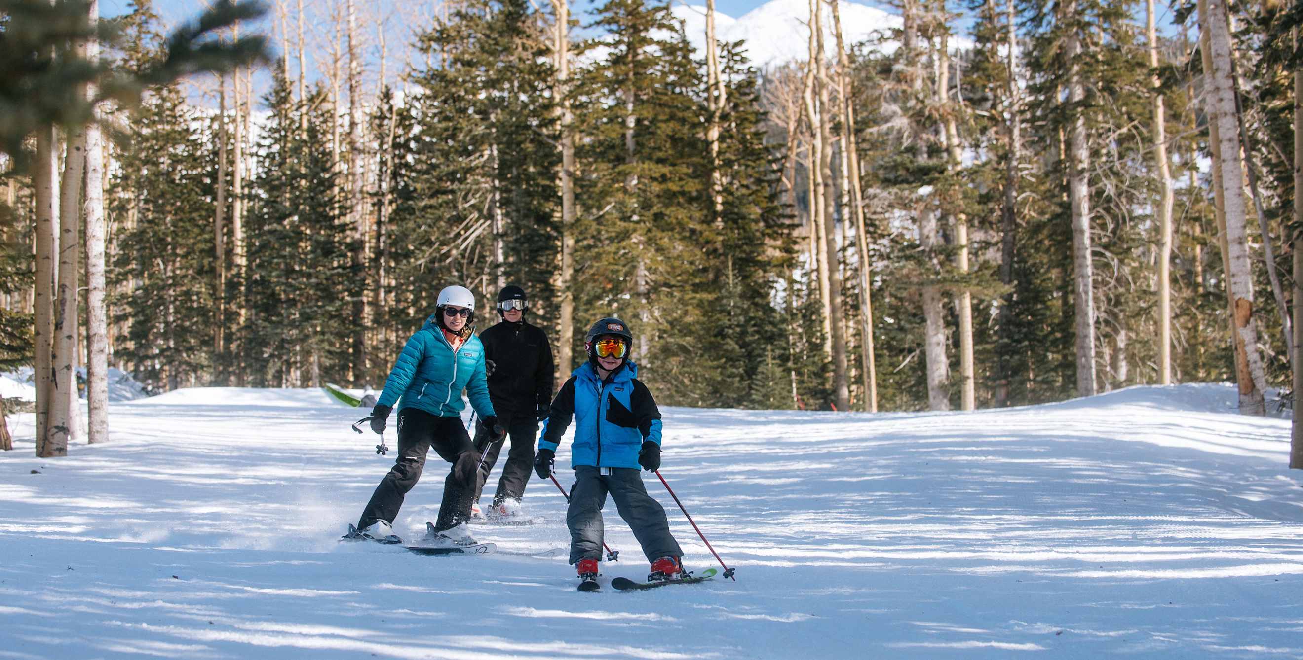 A family skies at Arizona Snowbowl in Flagstaff, Arizona.