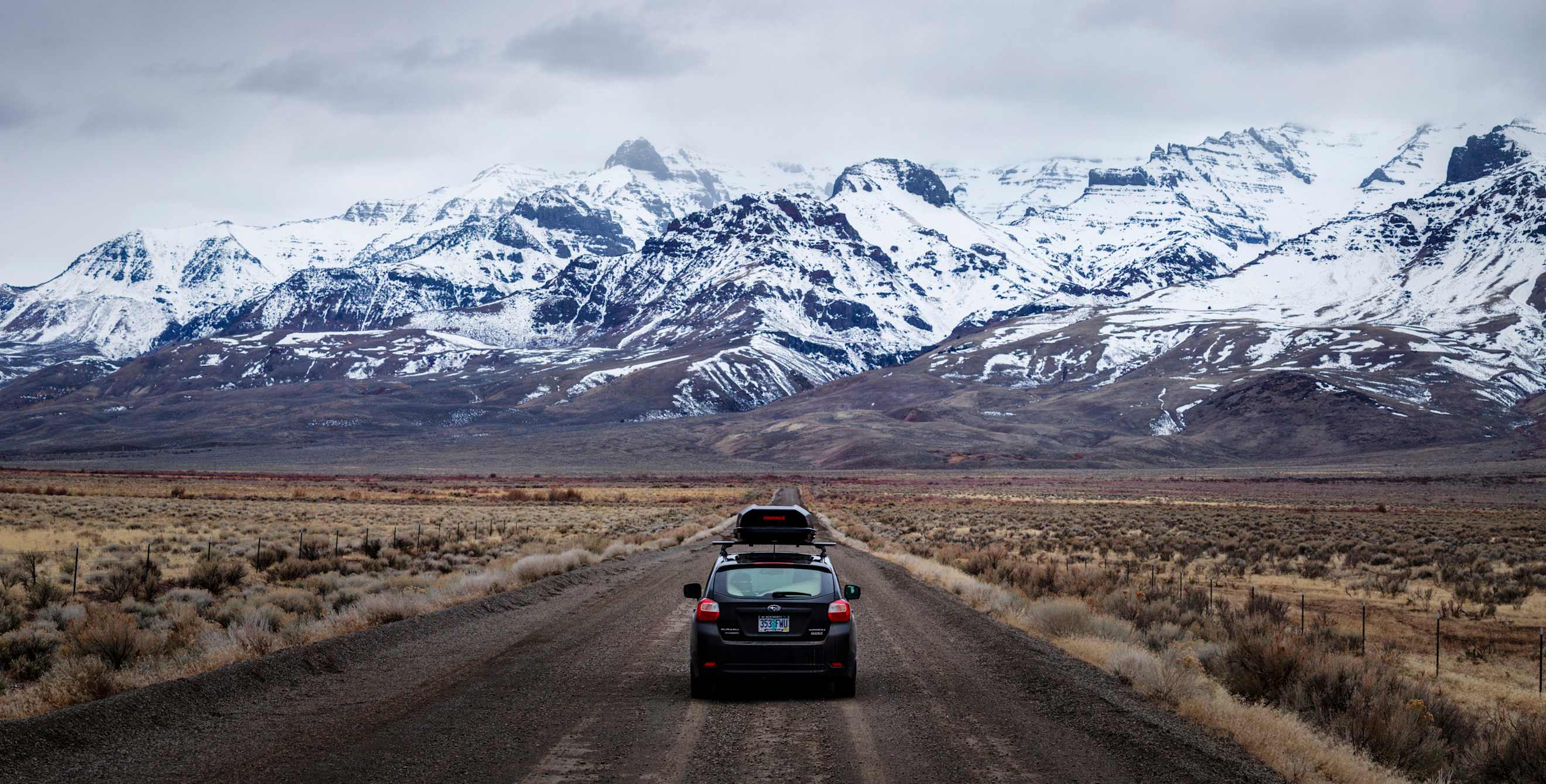A car dirt roads along the snow-covered Steens Mountains heading to the Alvord Desert in Southern Oregon.