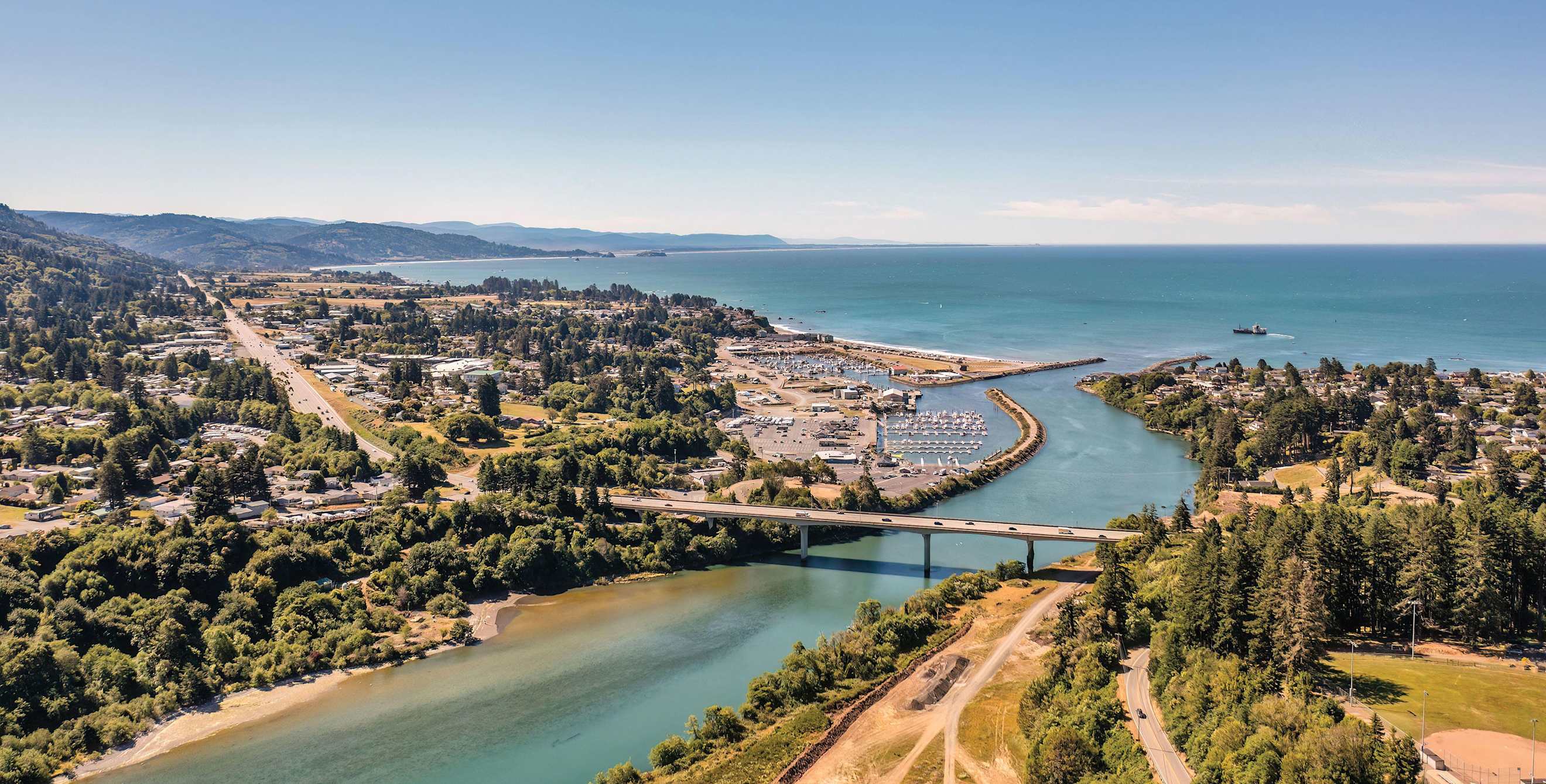 an aerial view of a river with a bridge going over it