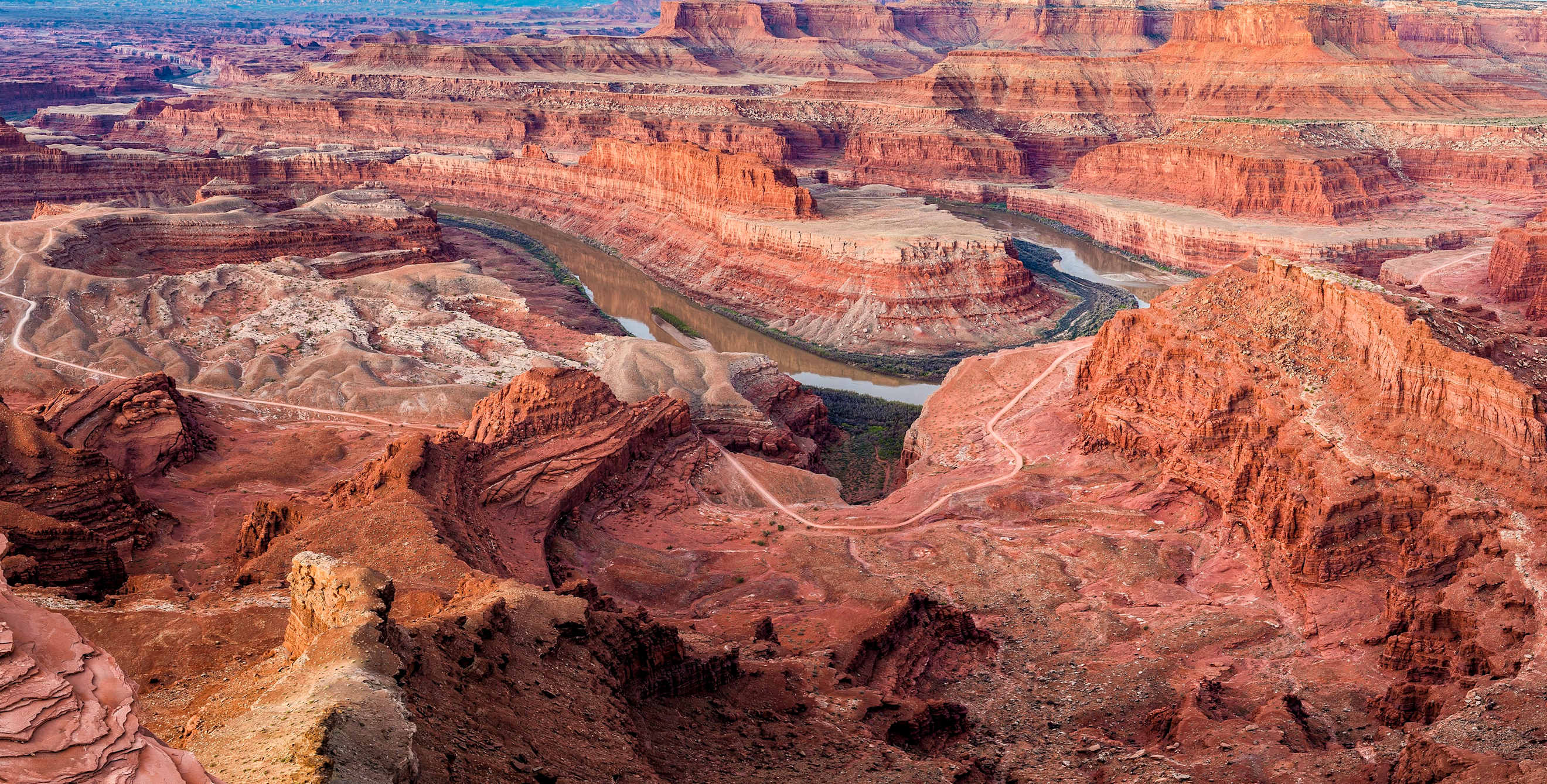 multicolor sandstone cliffs with the Colorado River winding through