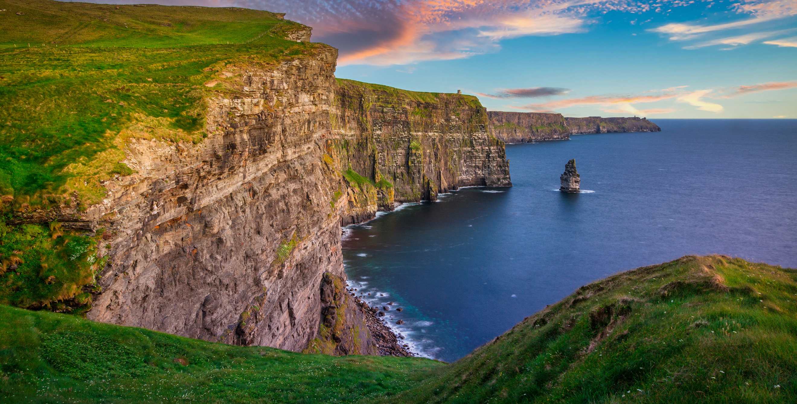 a beautiful sunset at green cliffs on the ocean in Ireland