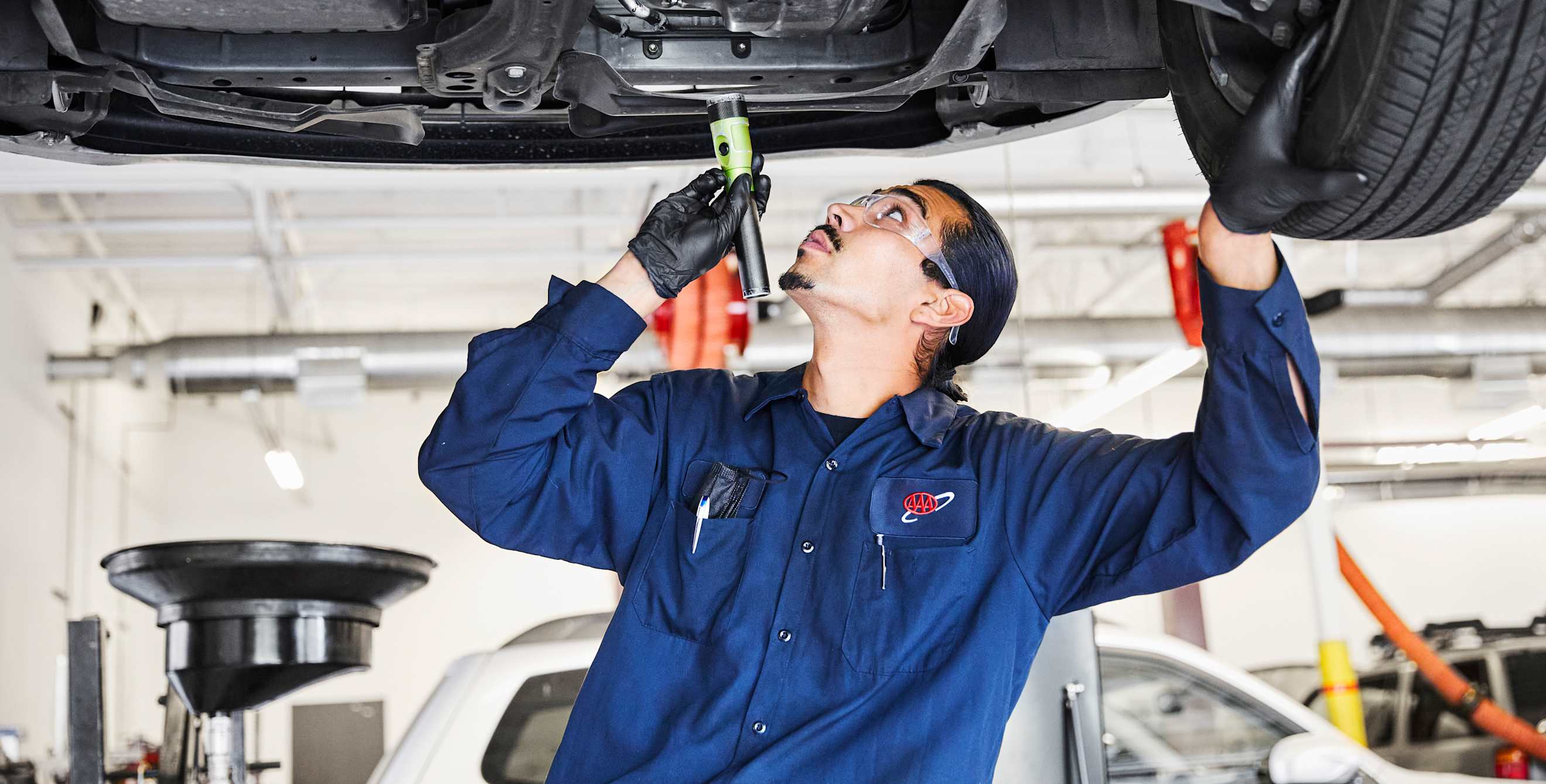 AAA Auto Repair mechanic inspects catalytic converter.