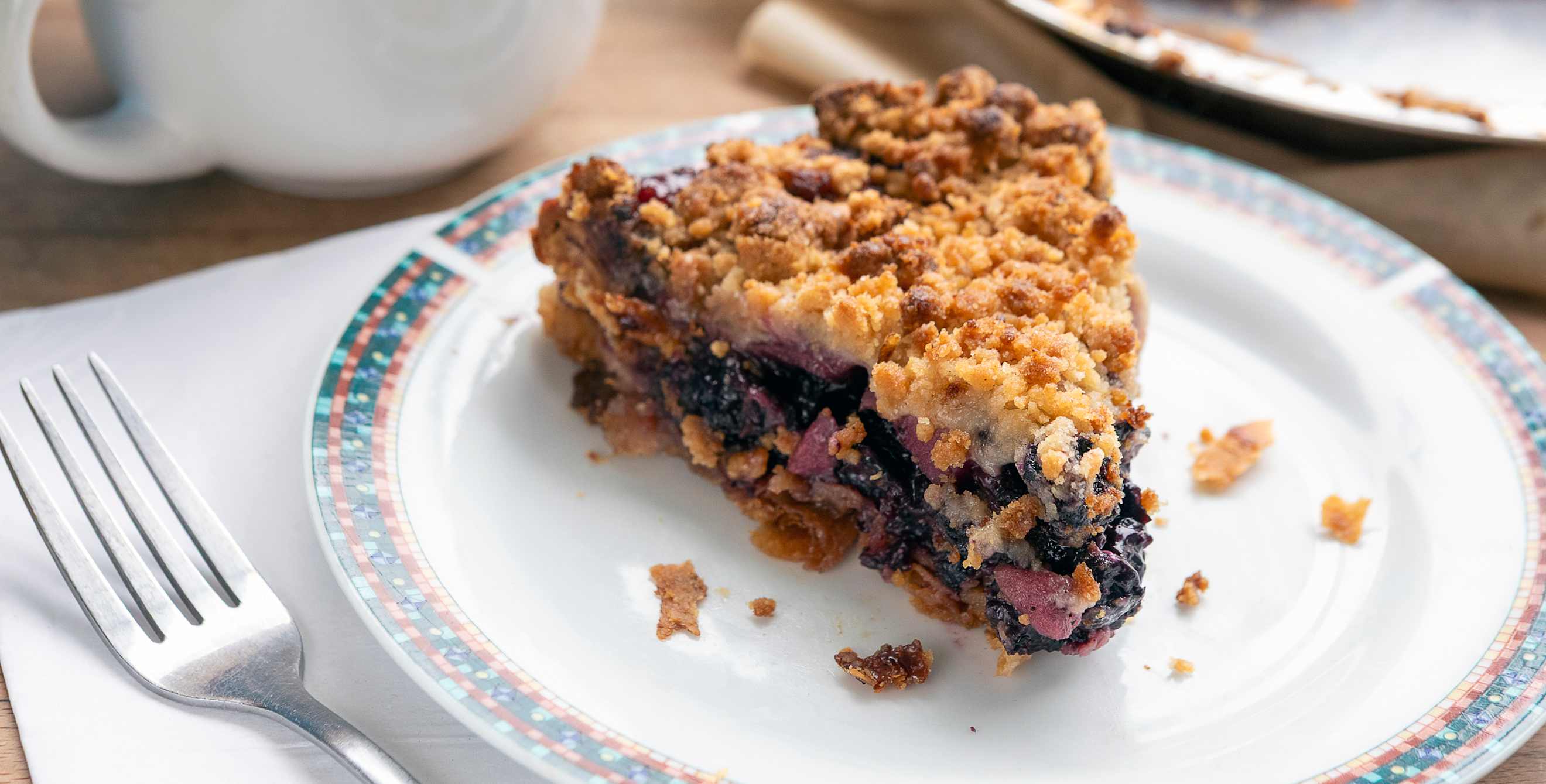 a piece of berry crumble pie on a white plate