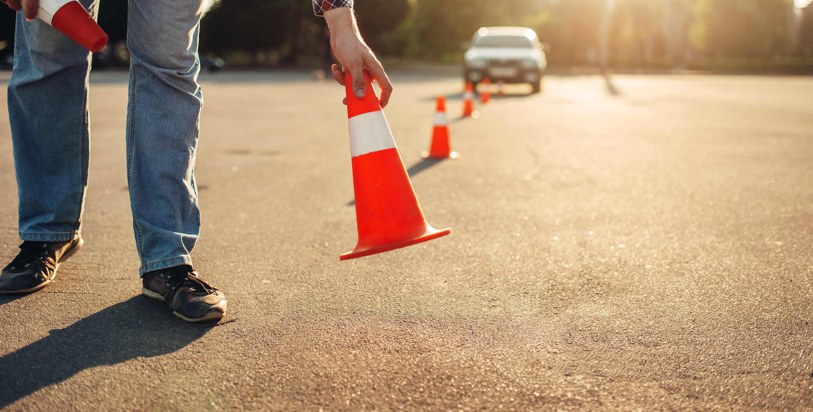 A driver's education instructor puts out cones.