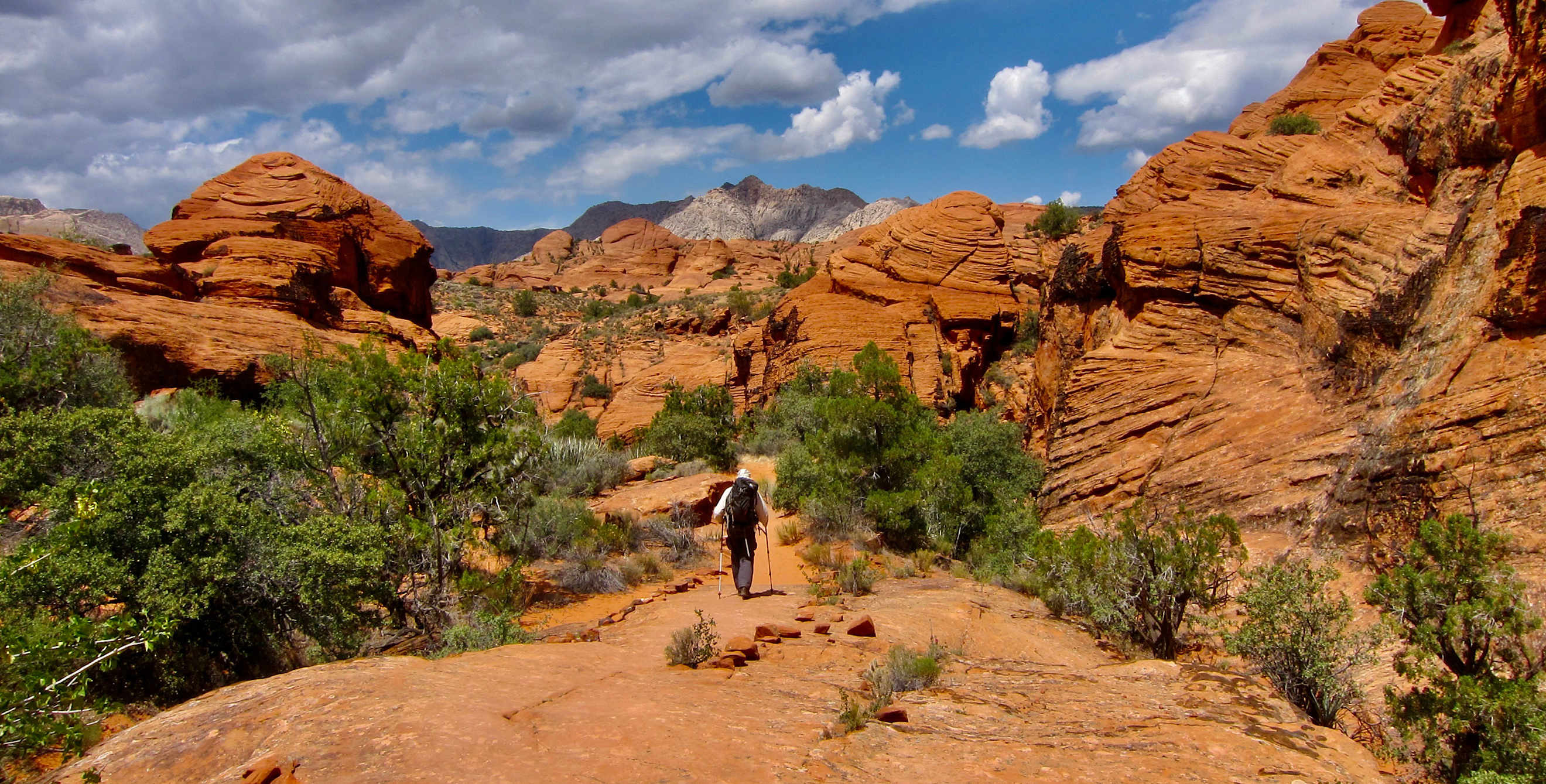 A hiker approaches a slot canyon in the desert