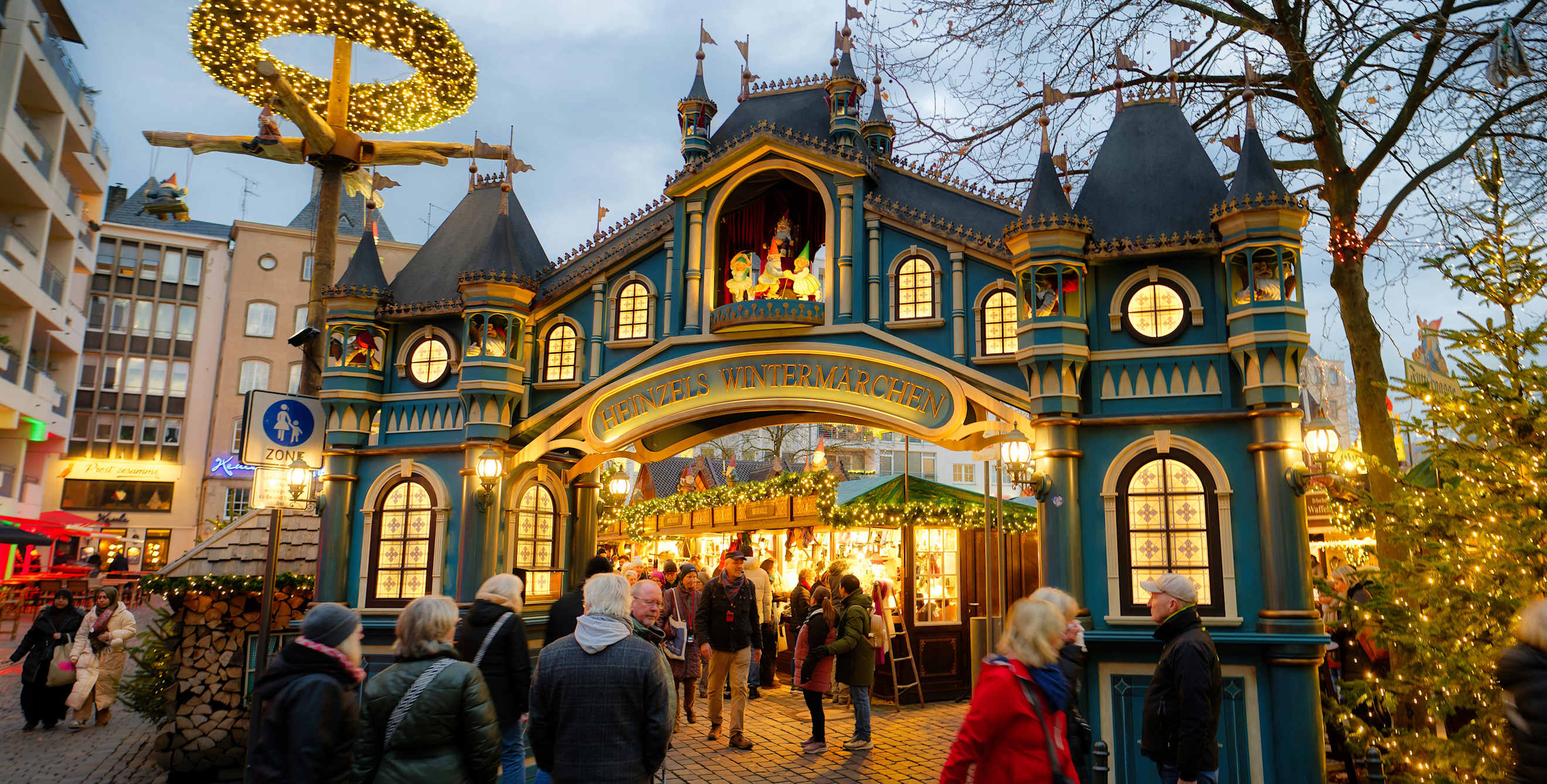 the entrance to a festively lit Christmas market