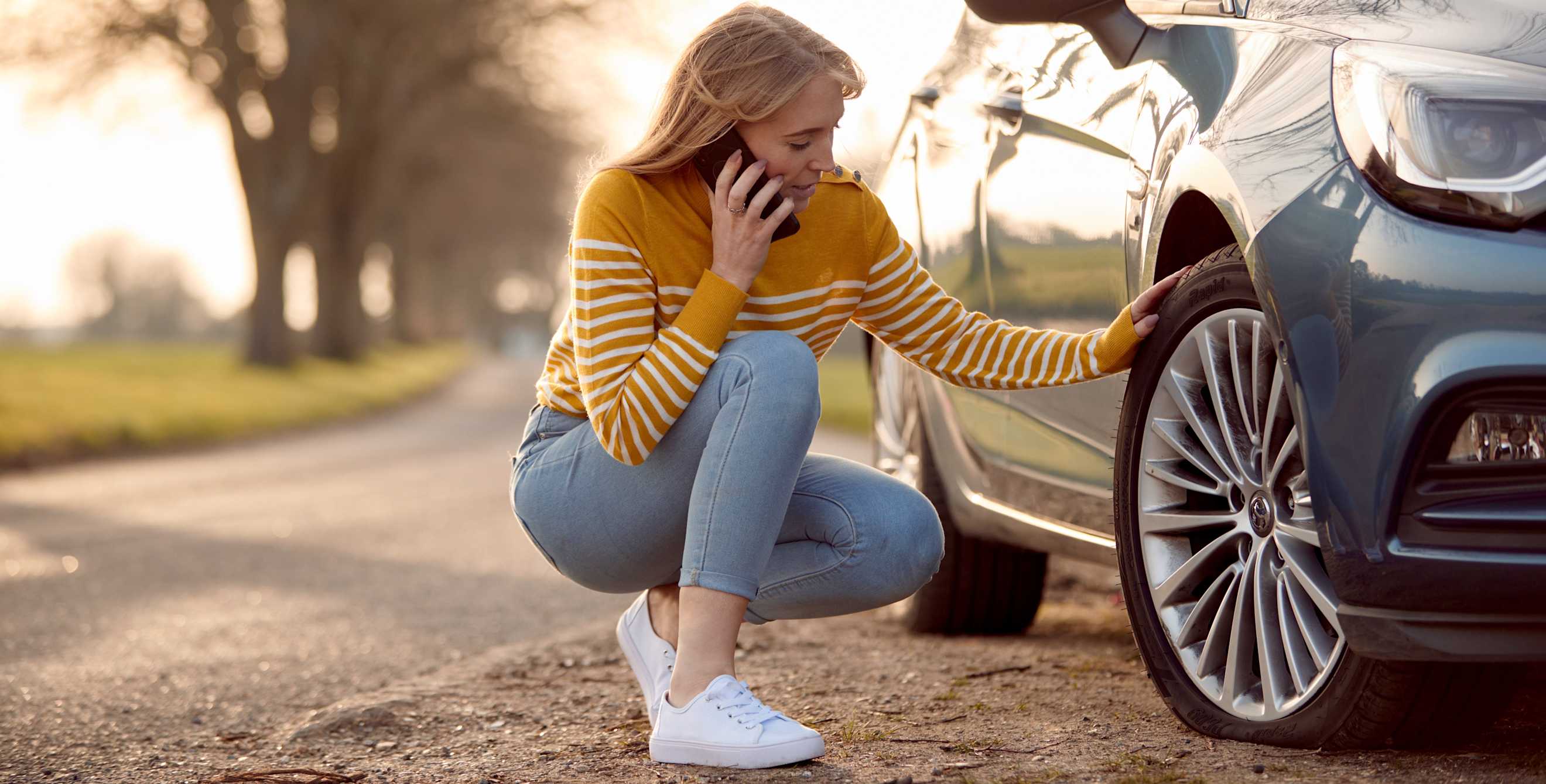 A woman with a flat tire calls for help.