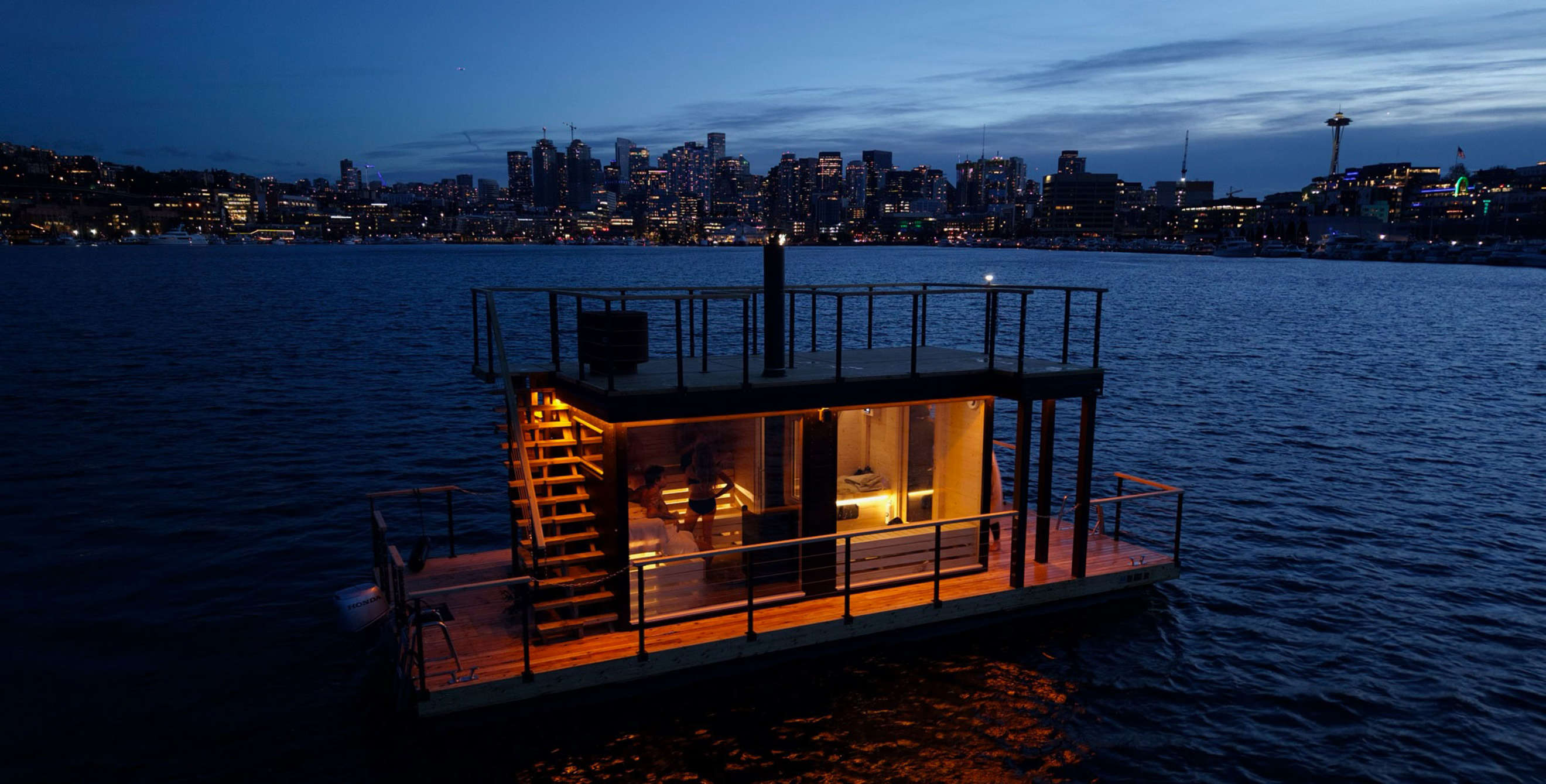 Floating Wild Haus nordic sauna on Lake Union, Washington, at dusk.