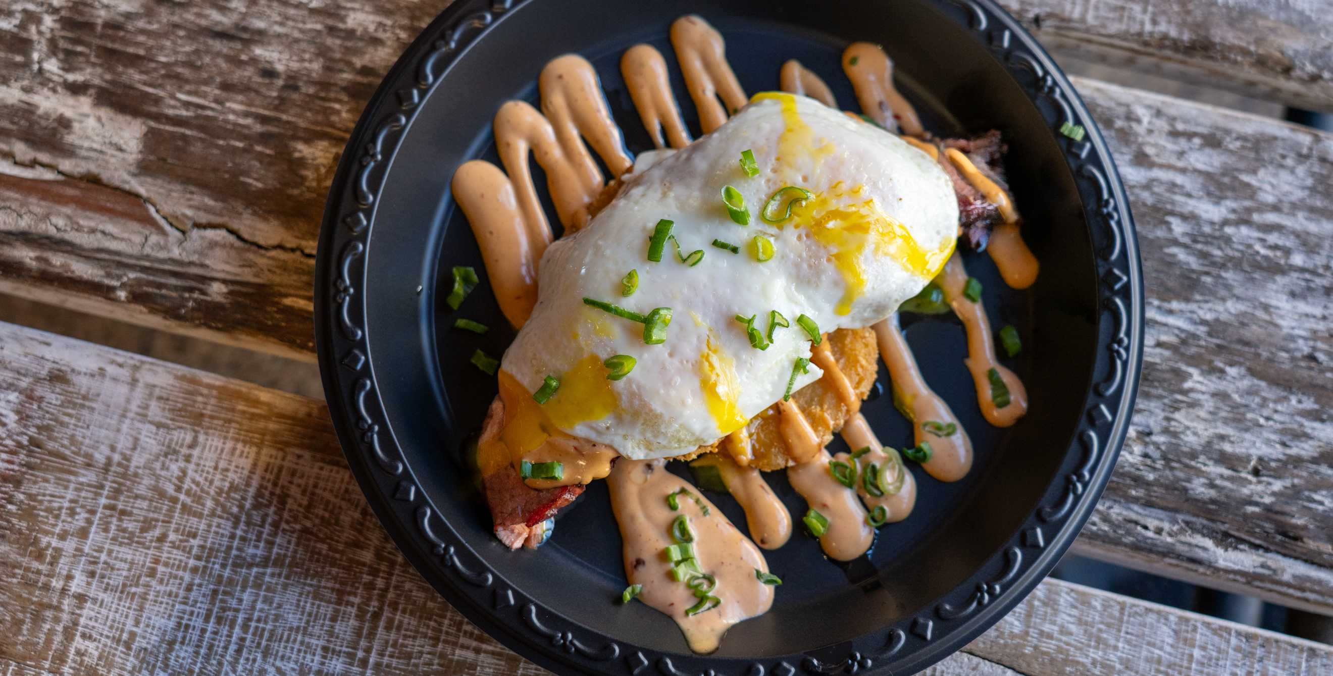 hash browns topped with eggs and sauce at The Thumb in Scottsdale, Arizona