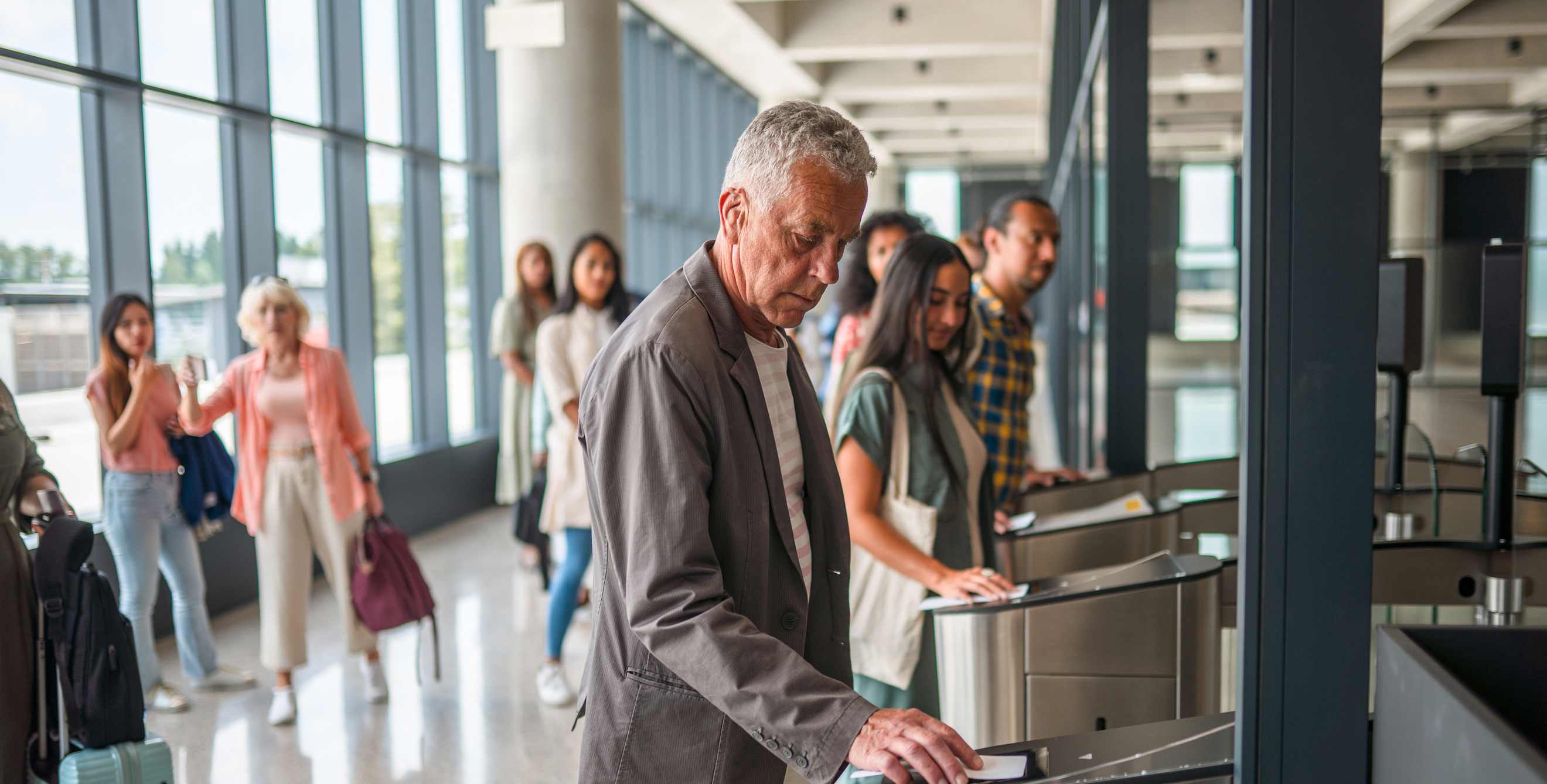 A passenger passes through a biometric screening gate before boarding a plane.