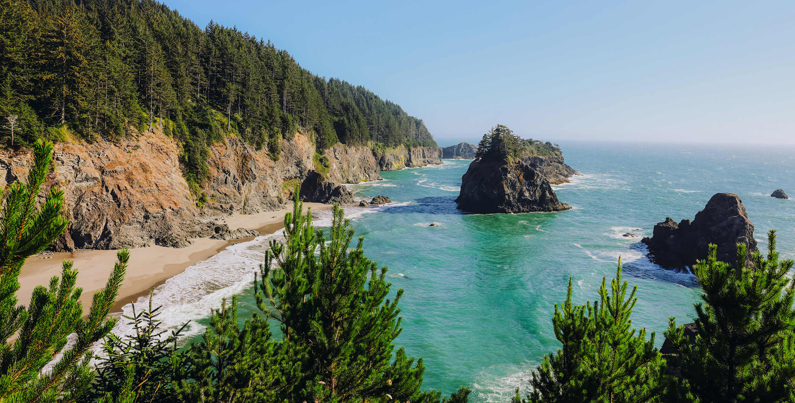 The Pacific Ocean crashes on the beach at Sue-meg State Park in California on a sunny day.