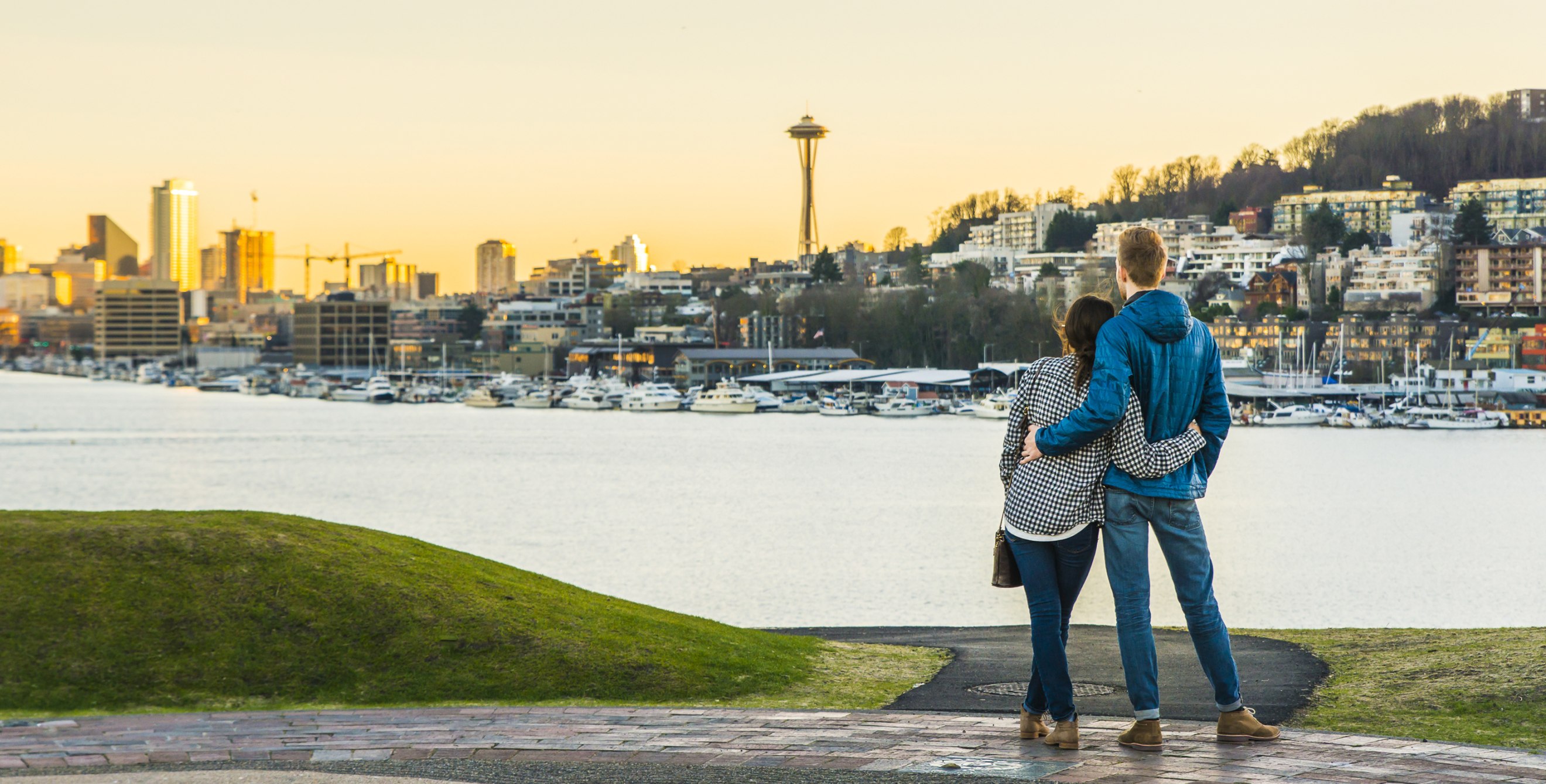 a couple looks out at the Seattle skyline, picture