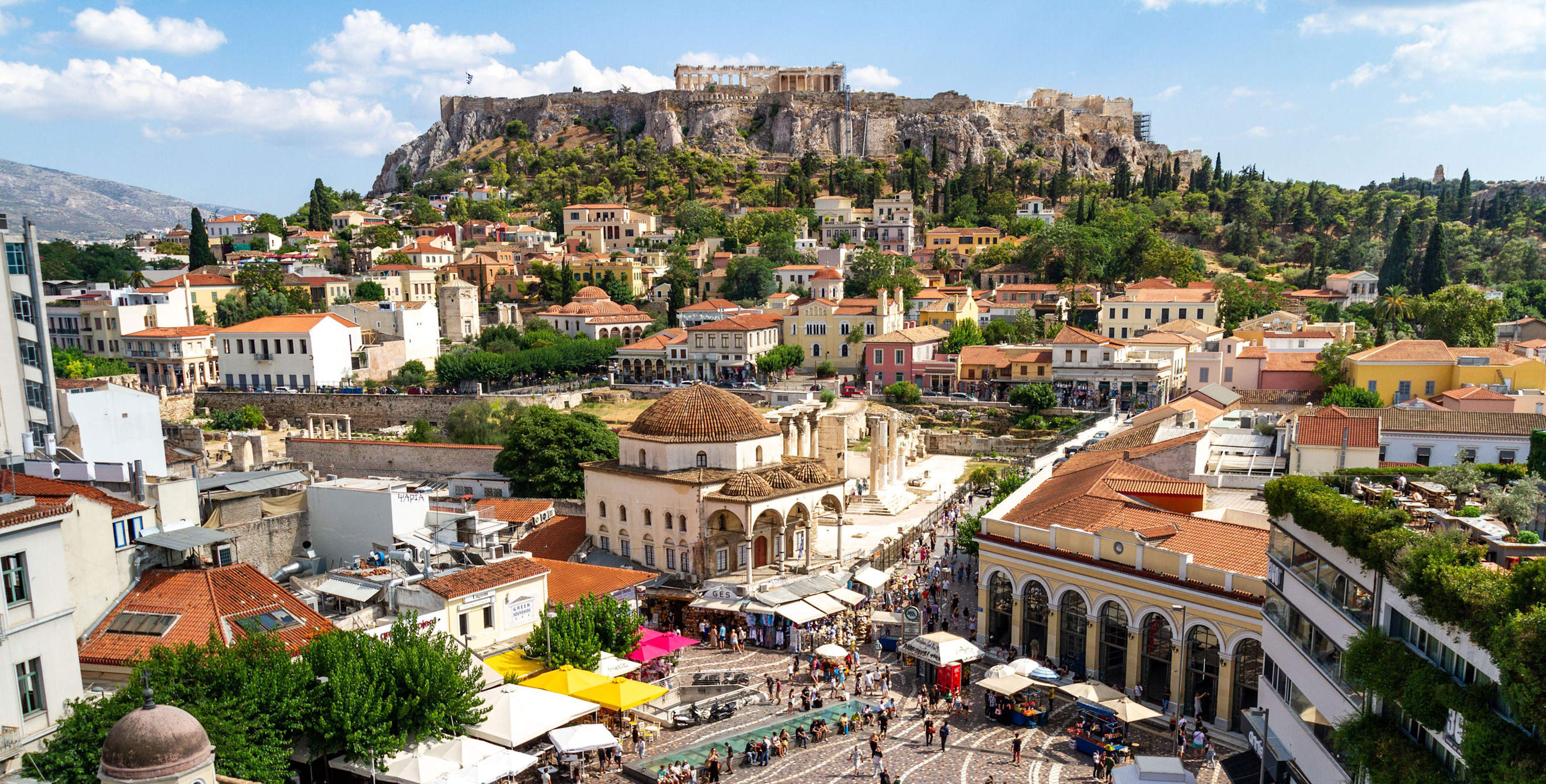 Elevated view of Monastiraki Square in Athens, Greece with the Acropolis overlooking the city in the background.