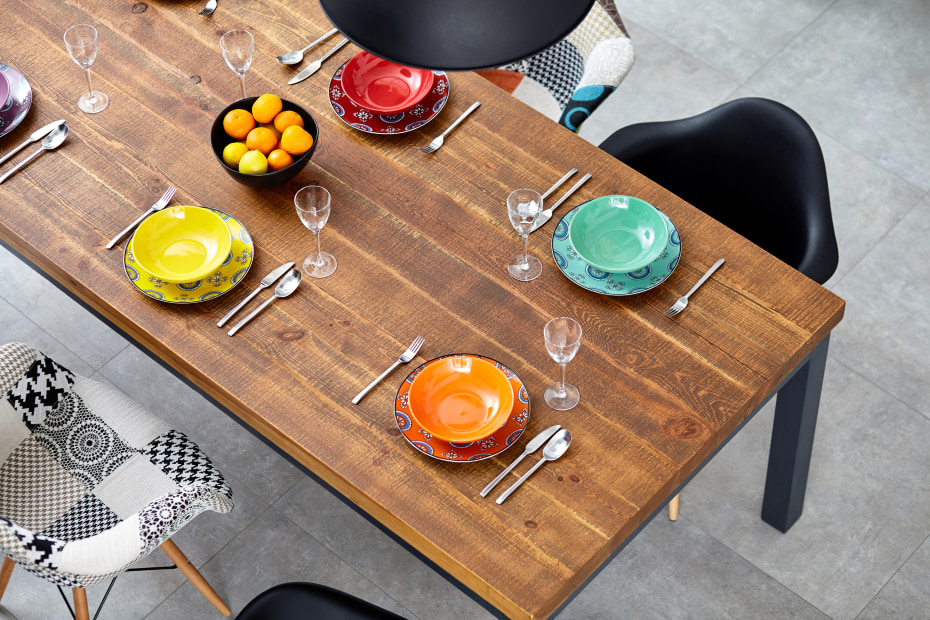 modern wood dinning room table with colored bowls and plates for a dinner party, picture