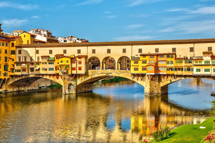 Ponte Vecchio in Florence, Italy in the middle of the day reflecting back on the water, image