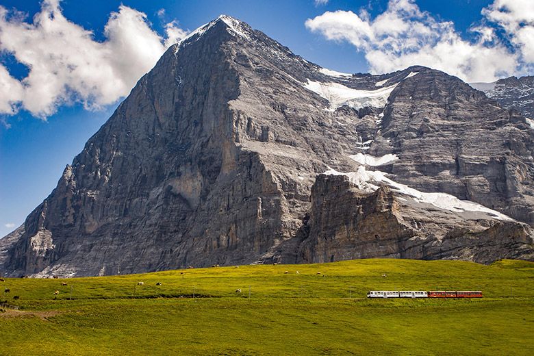 Switzerland's Jungfraujoch looms over passing train in foreground, picture