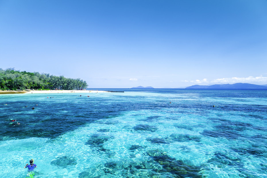 the great barrier reef from above with a man swimming in the foreground, picture