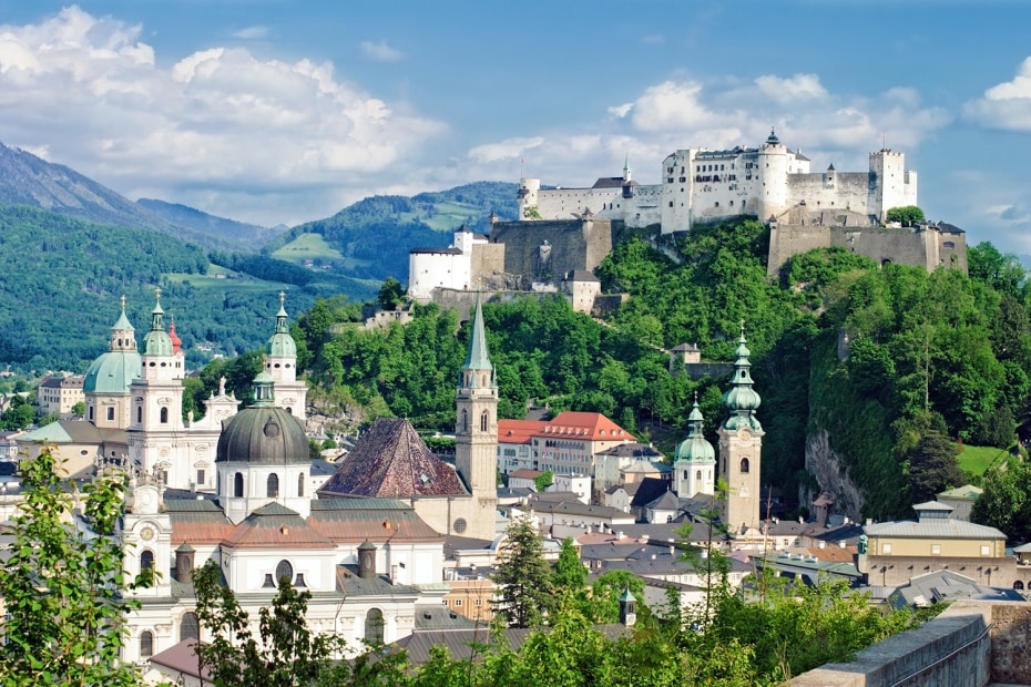 picture of the Hohensalzburg Fortress sitting atop a mountain above Salzburg, Austria