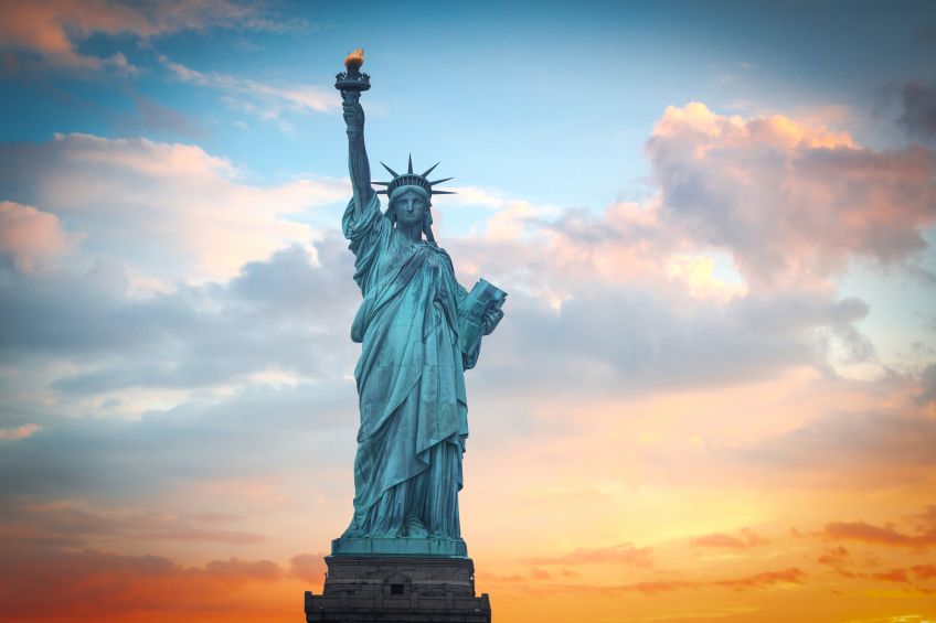 The Statue of Liberty at sunrise against orange sky, picture