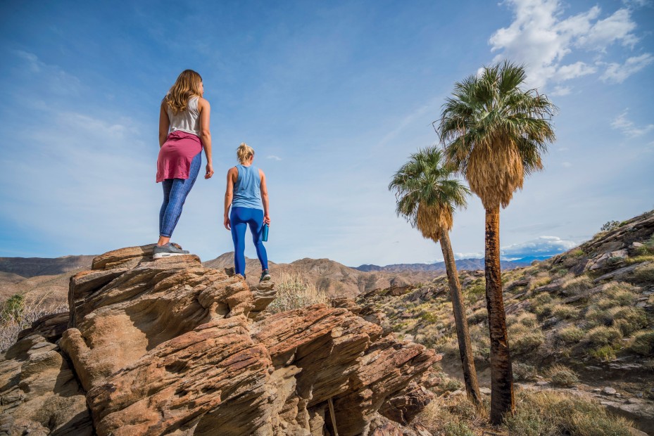 pair of casual day hikers survey the desert scenery from their rocky perch at Indian Canyons in Palm Springs, California, picture