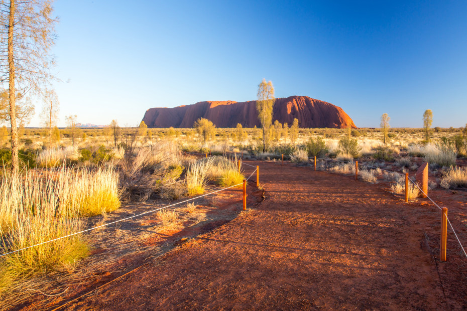 The trail that leads to Uluru Ayers Rock in Australia at sunrise on a clear winter morning, image