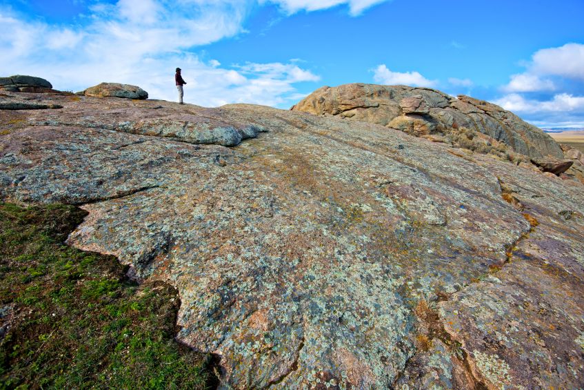 A hiker stands on Independence Rock State Historic Site in Wyoming, image