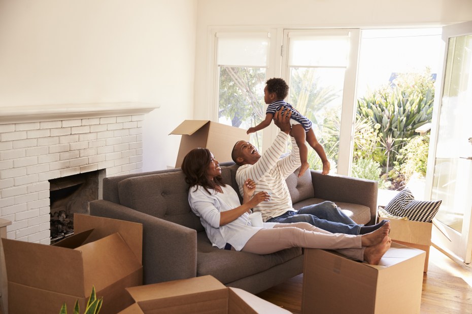 family relaxes on couch with baby while unpacking and moving into a new house, picture