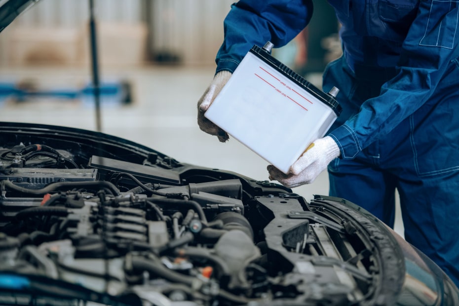 A technician replaces a car battery.