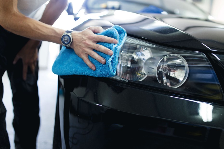 A driver polishes their headlights.