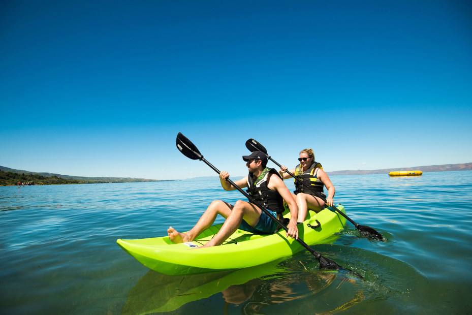 couple kayaking on waters of Bear Lake in Idaho with expanse of blue sky in the background