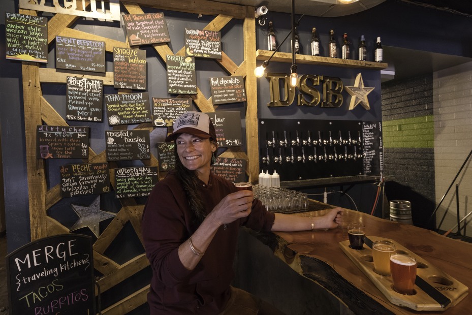 a woman pours beer at Dark Sky Brewing, picture