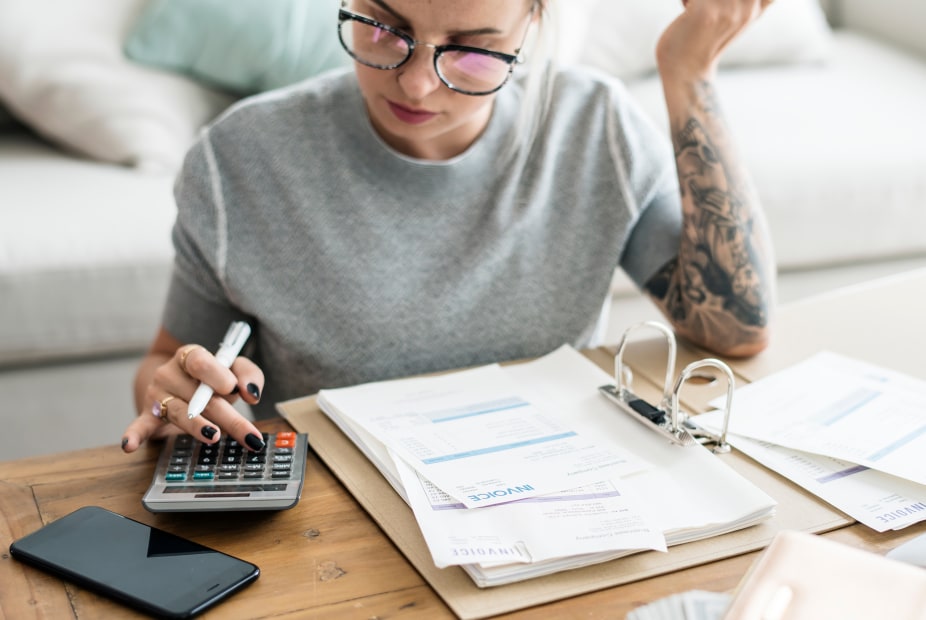 A woman sits at the coffee table and calculates finances, photo