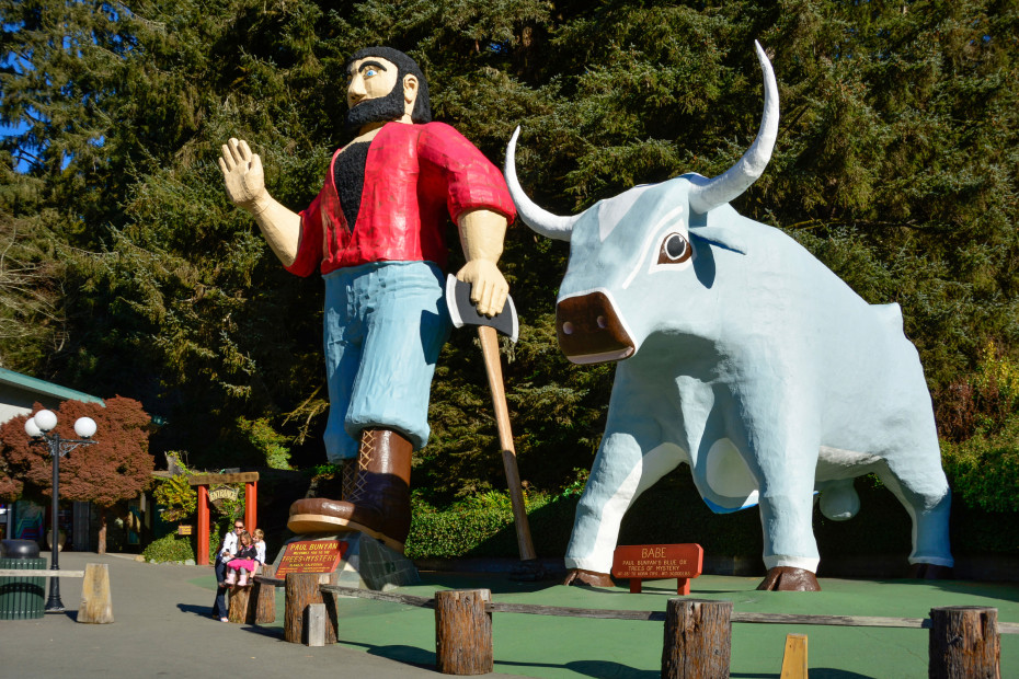 Paul Bunyan waves and leans on his ax beside Babe the Blue Ox, in Klamath, California