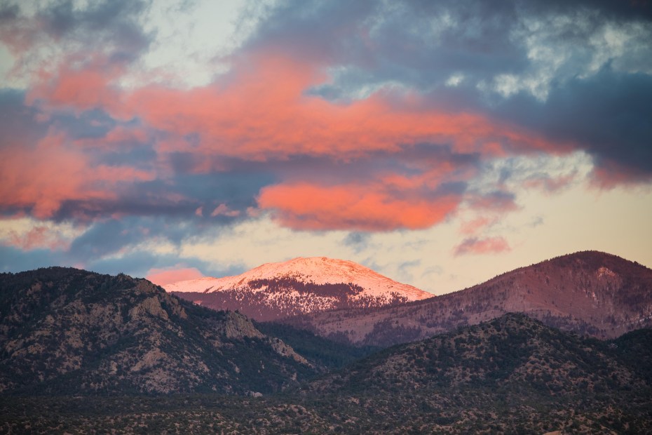 Dramatic sunset over the snow-capped peak of Santa Fe Baldy in the Sangre de Cristo mountains near Santa Fe, New Mexico.